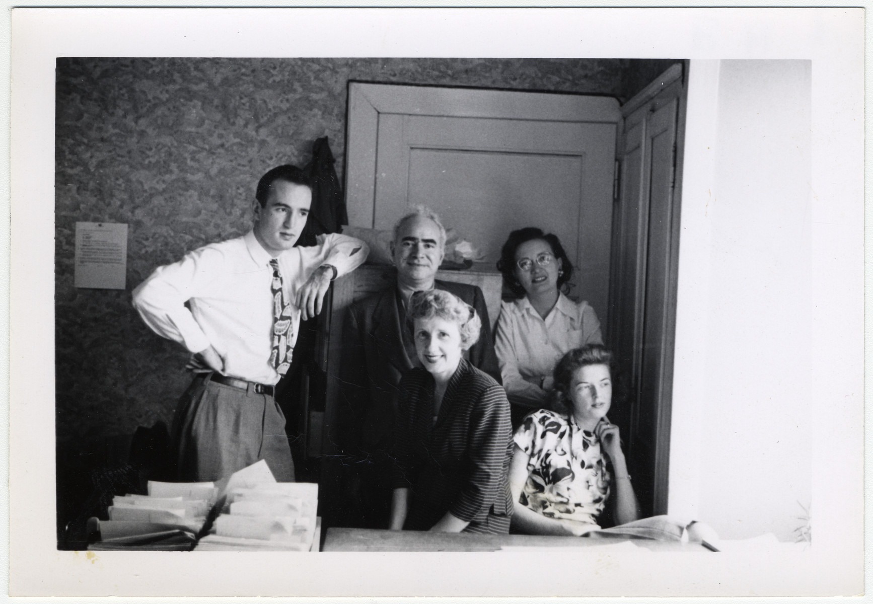 Maurice Levitt, a member of the Frankfurt Jewish GI Council, and four members of his staff work in their office in Bad Nauheim.

Maurice Levitt is standing in the center.  Else Jordan is in front of him.