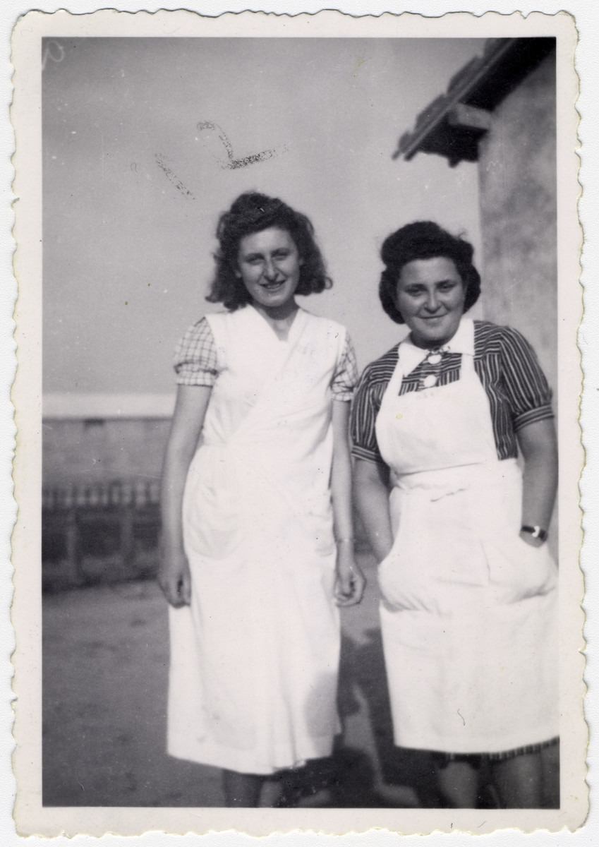 Two volunteer OSE workers, Dora Weissberg and Simone Lipman pose for a photograph outside a building in Rivesaltes. Original caption reads: "Dora & Simone. Two social workers, OSE."