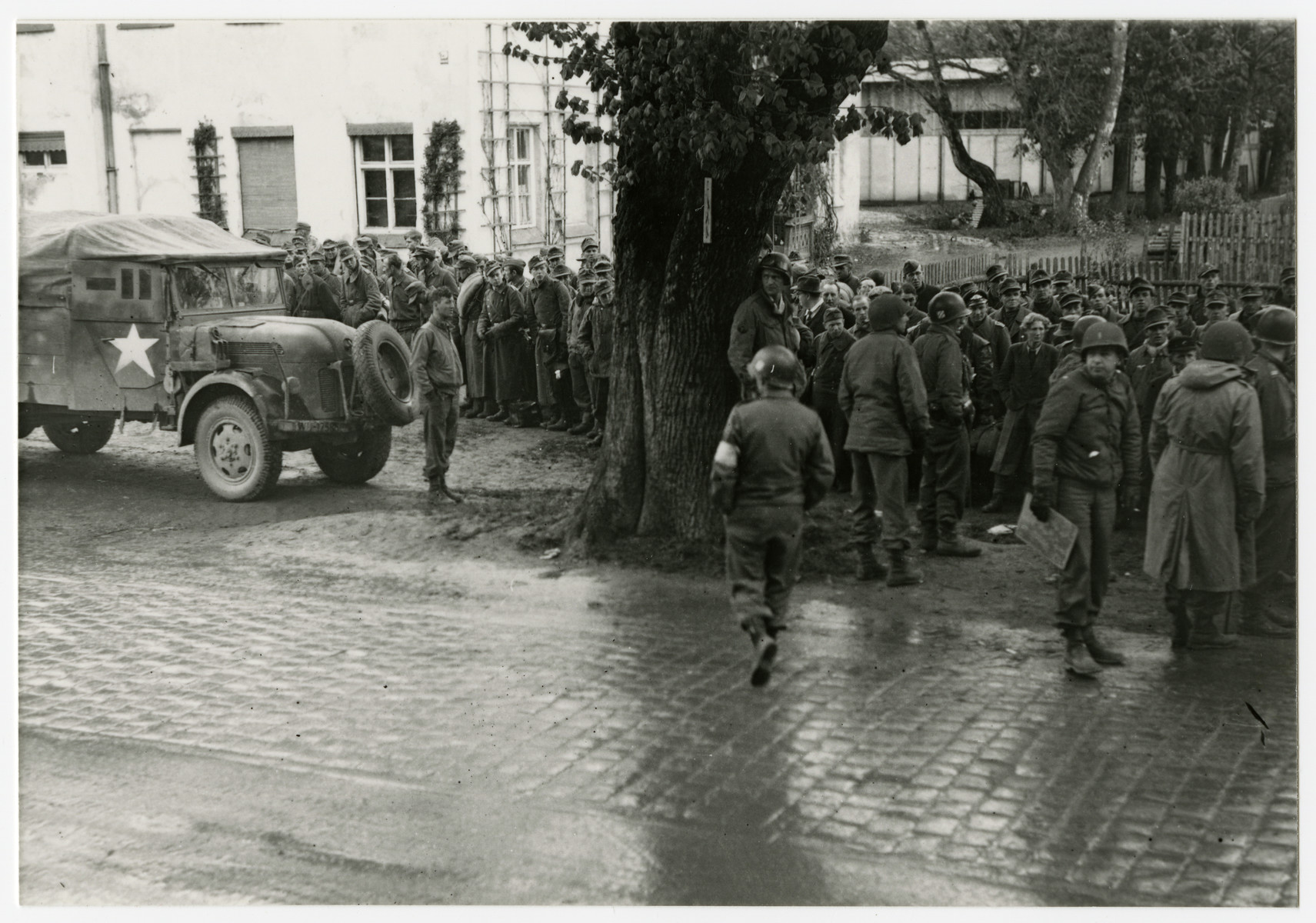 American soldiers stand guard over recently captured German prisoners.

The original caption reads" Munich 1945 -- We don't know what to do with all the prisoners."