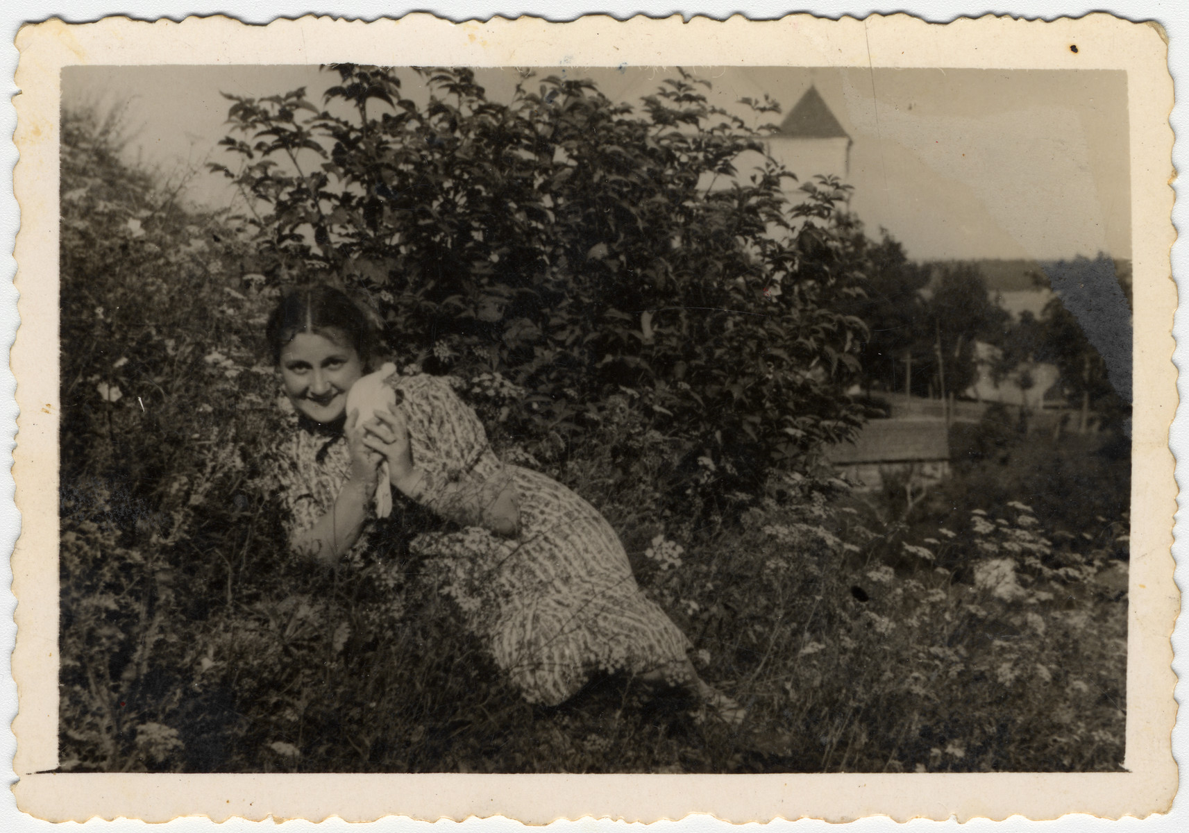 Sonia Boldo lies in a flower bed holding a kitten in prewar Nowogrodek.

Sonia escaped from the Nowogrodek ghetto in 1942 and came to the forest.  There she met and married Zus Bielski.