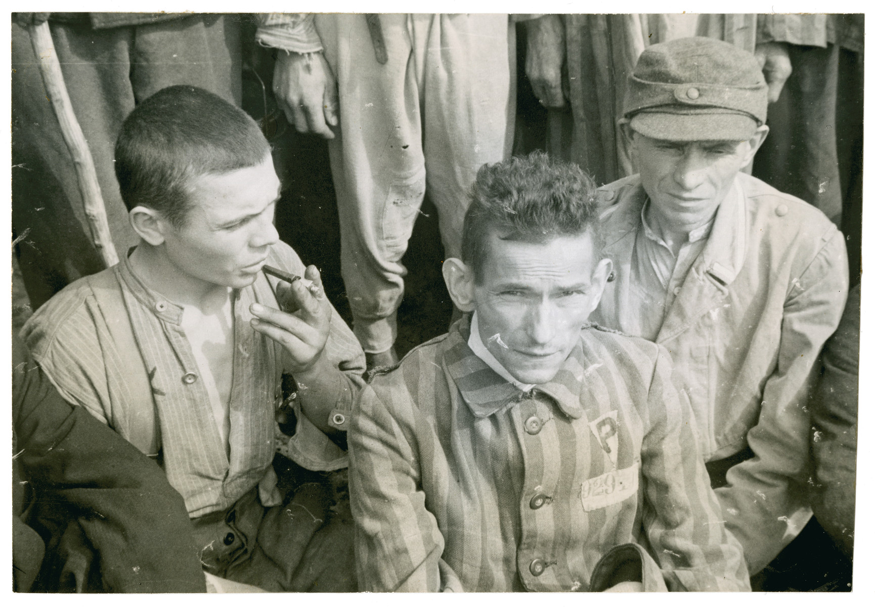 A close-up of three survivors at a gathering in the Langenstein-Zwieberge concentration camp.

The man on the right has been identified as Robert Nardou.