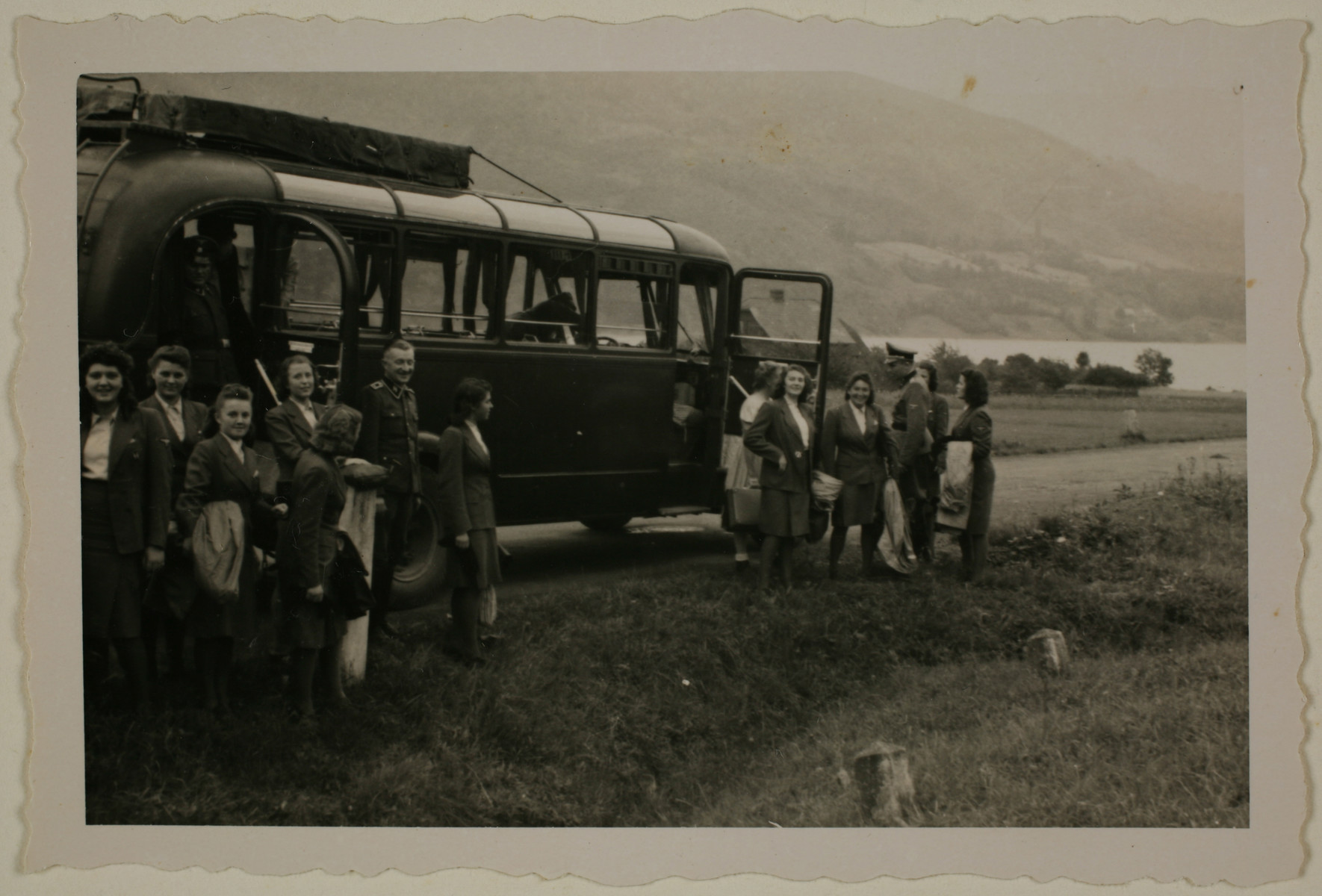 Members of the SS Helferinnen (female auxiliaries) arrive by bus at Solahuette, the SS retreat near Auschwitz. 

The original caption reads "Mit den SS Maiden auf der Solahuette 22.7.44" [with the SS maiden in Solahuette 22.7.44].