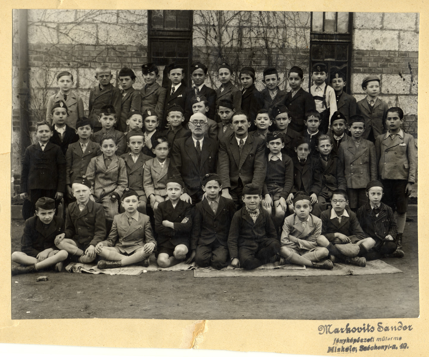 Class portrait of the fourth grade of the Erszebet Izraelita Elemi Iskola (the Jewish elementary school) in Miskolc.

Most of the students perished two years later.
Pictured are (top row): Gyorgy Czeisler, Laszlo Groszman, Imre Wruszerbai, Andor Weisz, Erno Neuwalder, Gyorgy Adorjan, Dezso Markovits, Lajos Gotlib, Miklos Herskovits, Gyorgy Varadi, Peter Bonis, Jeno Schlezinger, and Salamon Silberman.  Third row: Erno Roth, Laszlo Schwarz, Istvan Bornstein, Istvan Ronai, Zoltan Klein, Miklos Rosenberg, Pal Mandel, Laszlo Markusz, Erno Deutsch, Erno Pugacs, Erno Lichner, Sandor Lusztig, and Arthur Ungar. Second row: Adolf Roth, Jozsef Komlos, Marton Lefkovits, Miklos Zsupnik. Istvan Feig, Bertalan Hauer (school principal), Jozsef Buxbaum (teacher), Janos Kovacs, Gyorgy Weisz, and Tibor Markusz.  Front row: Abel Winger, Gyozo Kohn, Pal Kovacs, Laszlo Goldstein, Miklos Schoenbrun, Gyla Gruen, Lazar Preisz, Pal Rozenfeld and Sandor Stern.