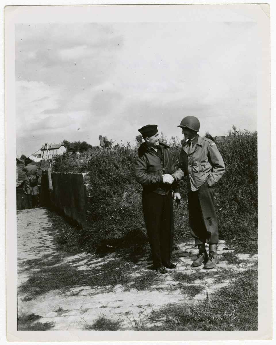 Fred Astaire shakes hands with a US soldier during his goodwill visit to France.

The original caption reads "Fred Astaire visits Normandy. Astaire is on the right."