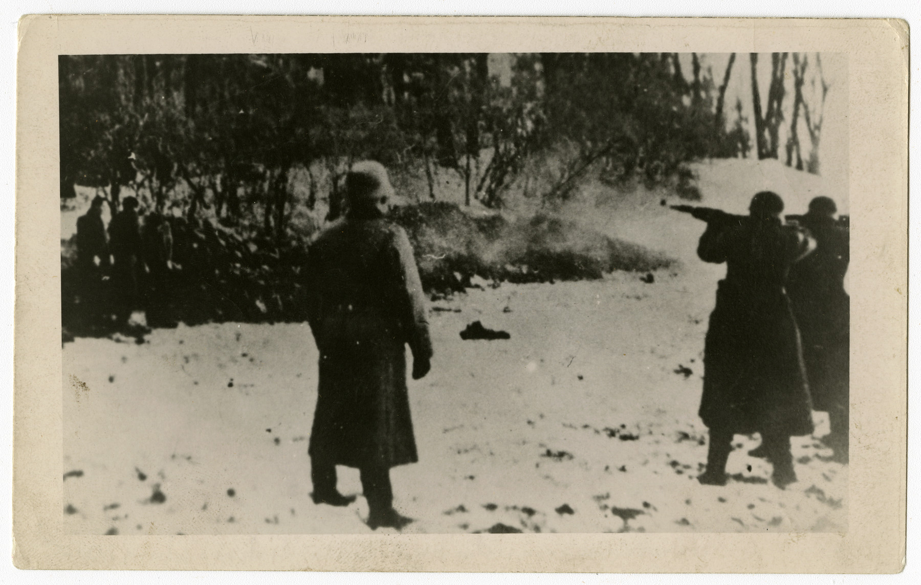 German police execute Poles at the edge of the Uzbornia Grove just outside of Bochnia. 

The original caption in Polish reads:

"From a series of Nazi crimes during the occupation of Poland

The forest near Bochnia
Execution in the forest...

Published by the Jewish Historical Commission of Katowice"

This widely circulated copy print (see WS# 73831) is one found by Jacob Igra in an apartment in Sosnowiec after the war. Many of the photographs are believed to have been taken by a soldier with the SD-SIPO (Sicherheitspolizei) following the invasion of Poland in 1939. Additional photographs depict einsatzgruppen activities at sites throughout Nazi occupied Eastern Europe and are likely later additions to the album.