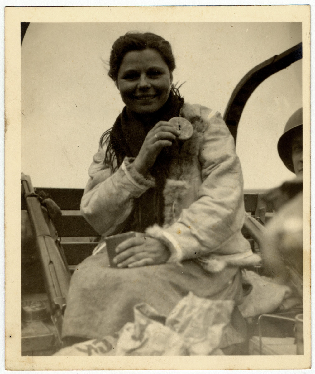 Close-up portrait of a newly liberated, female, Russian slave laborer eating American rations.

The original caption reads: "Russian Slave Labor: First delicacy since internment.  Our much disliked "C" rations.  Liberation was sweet.  Notice she got one of our fur jackets".