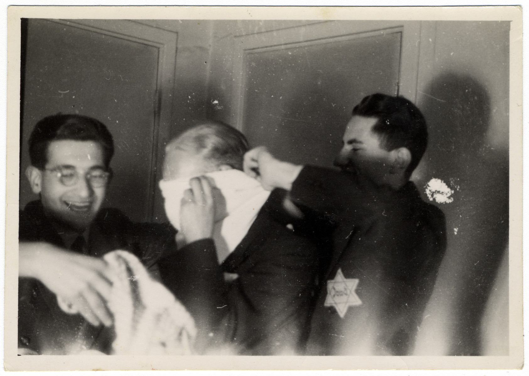 Jewish teenagers play a game with a blindfold at a party hosted by Rudy Acohen (left).

Shortly thereafter he was arrested in a reprisal action and sent to Auschwitz where he perished.