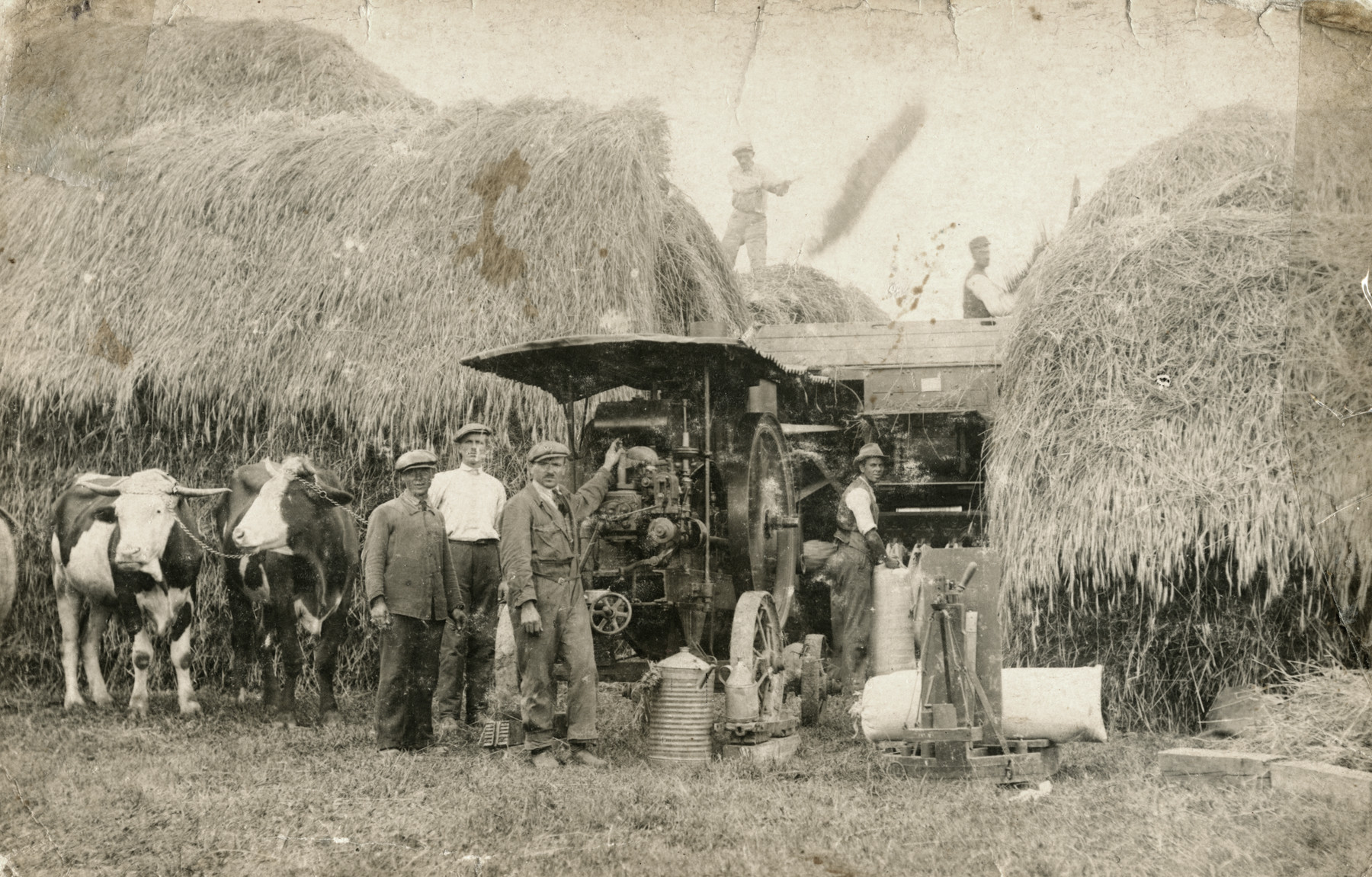 Avraham Bernat Koviliak (center) works with a threshing machine on a farm in the summertime.