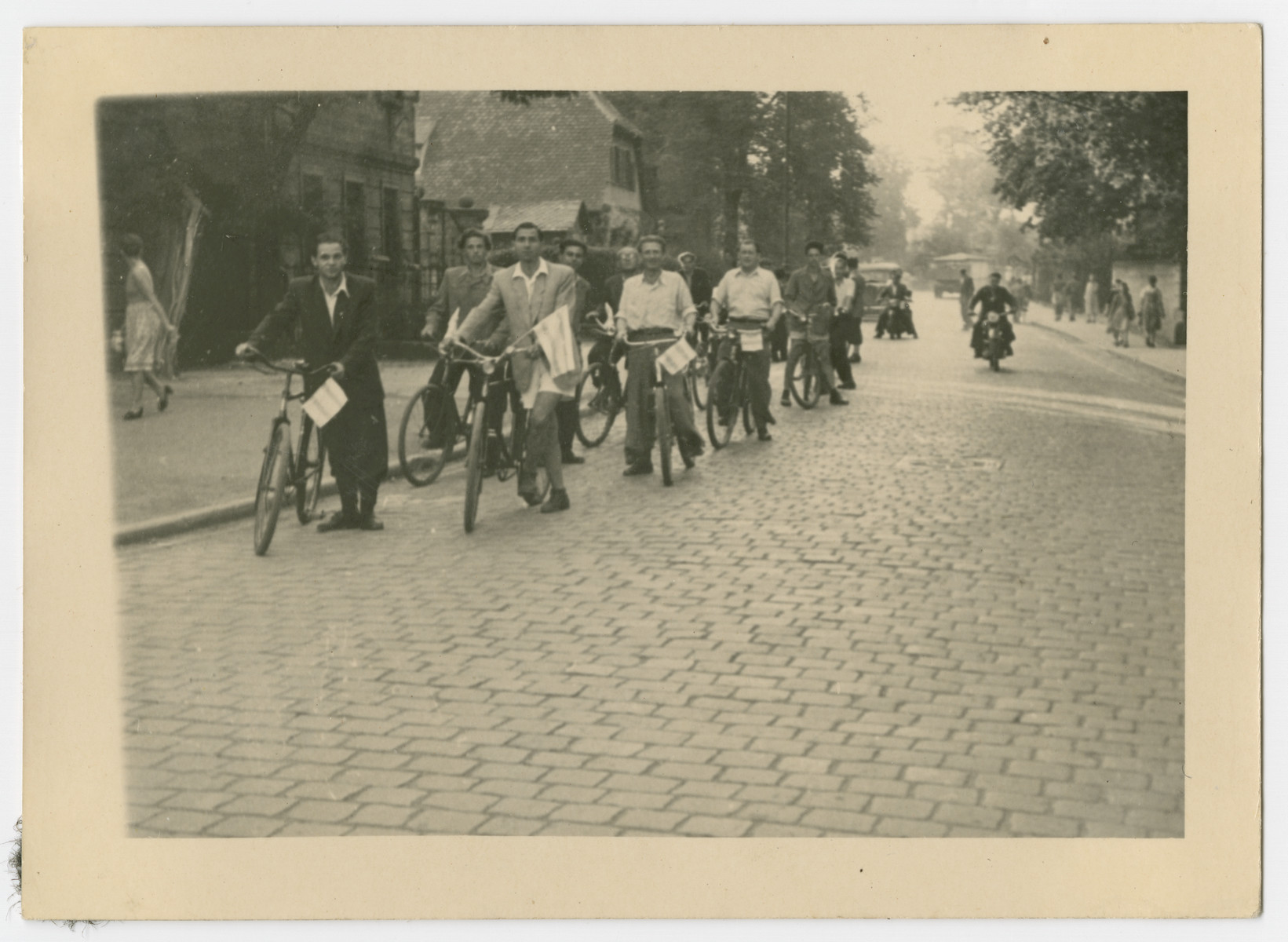 Jewish displaced persons form a bicycle parade holding Zionist flags.