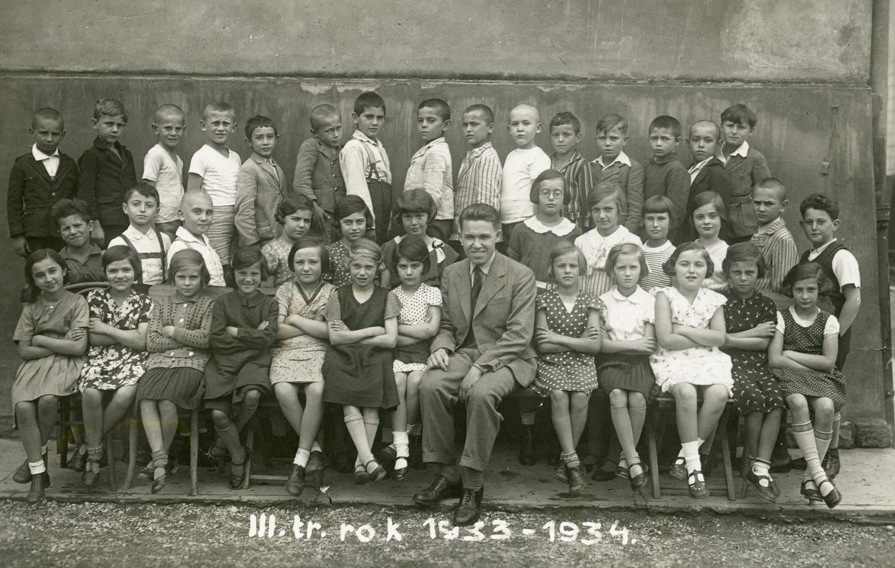 Children in the third grade of the Jewish elementary school in Zilina.

Among those pictured is the teacher Simon Goldberger (later Golan) and Bandi Jaacob Sigmund.   Liselote Stein is seated on the left.  Eva Schneller (later Grunwald) is seated in the front row, on the far right.