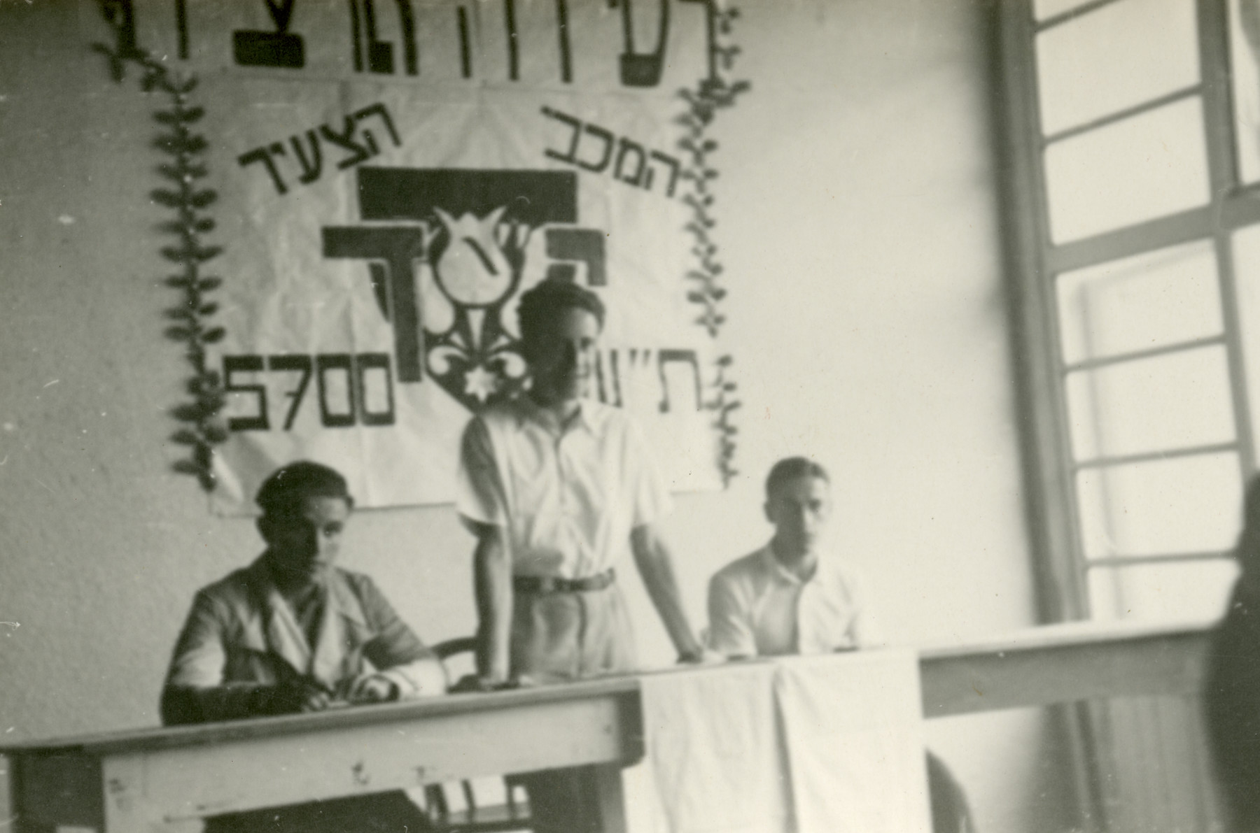 Leaders of the Maccabi team hold an opening ceremony in their summer camp in Czernohorske Kupele.

Pictured from left to right are Peretz Revesz, Eli Sajo and [possibly Josef Berger].