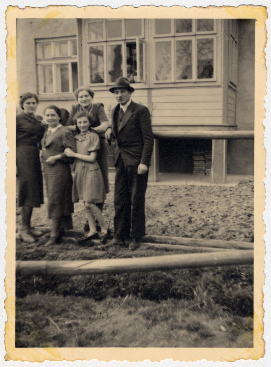 Group portrait of the Honig and Rozenblit families standing outside a building in Tarnow.