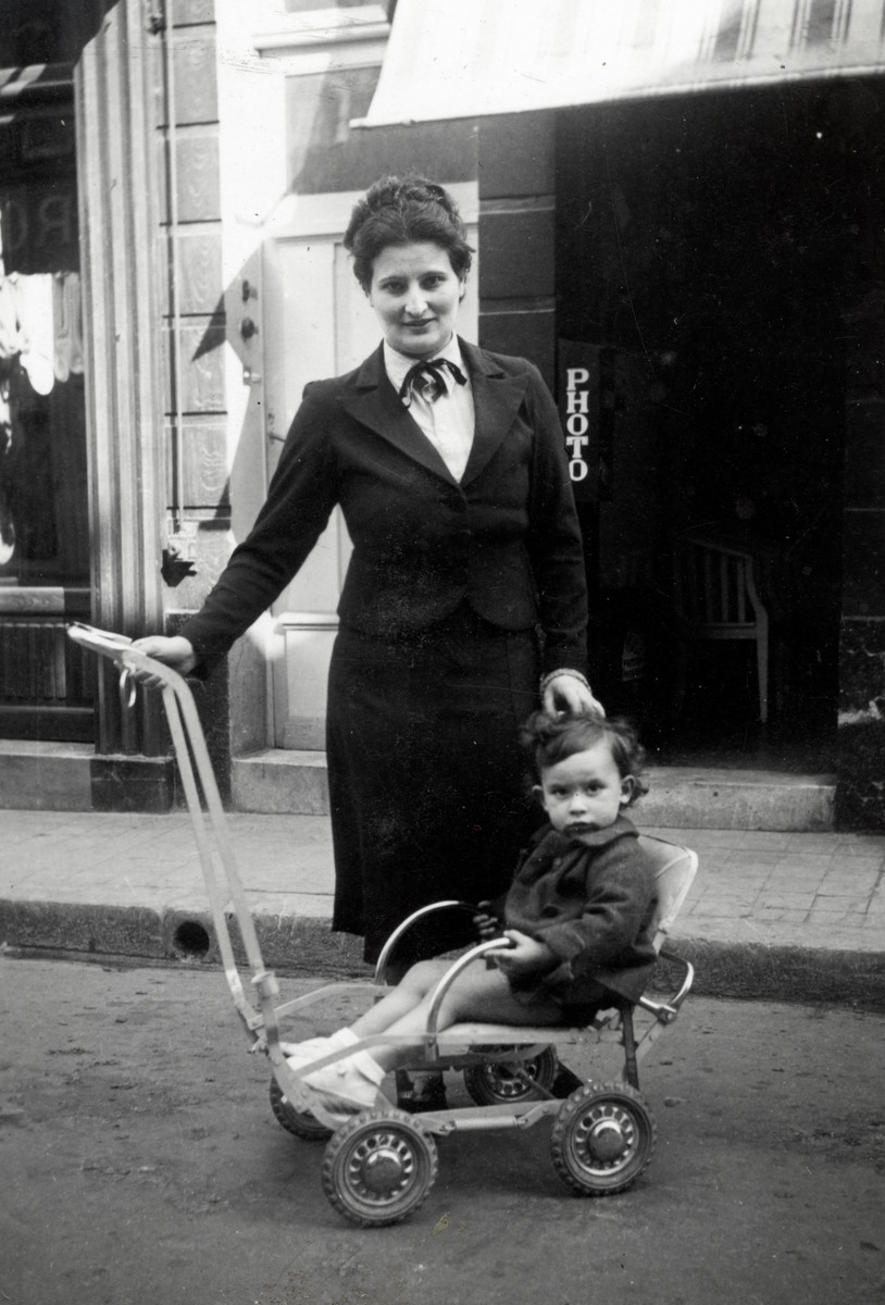 Suzanne Michel poses with her young son Jacques who is sitting in a stroller.