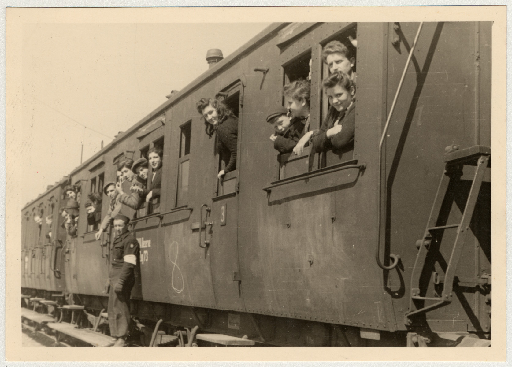 Displaced persons look out the windows of a train as they prepare to return home and be repatriated.