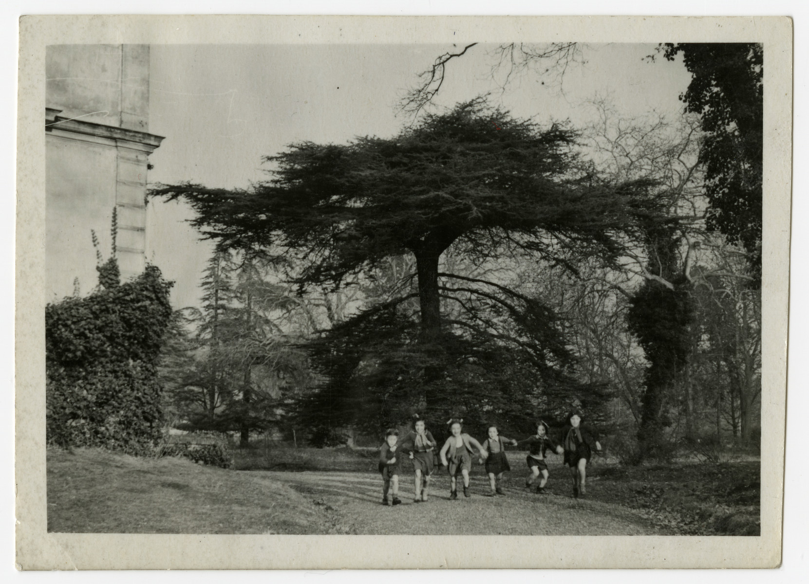 Children run outside on the grounds of the OSE Taverny children's home.