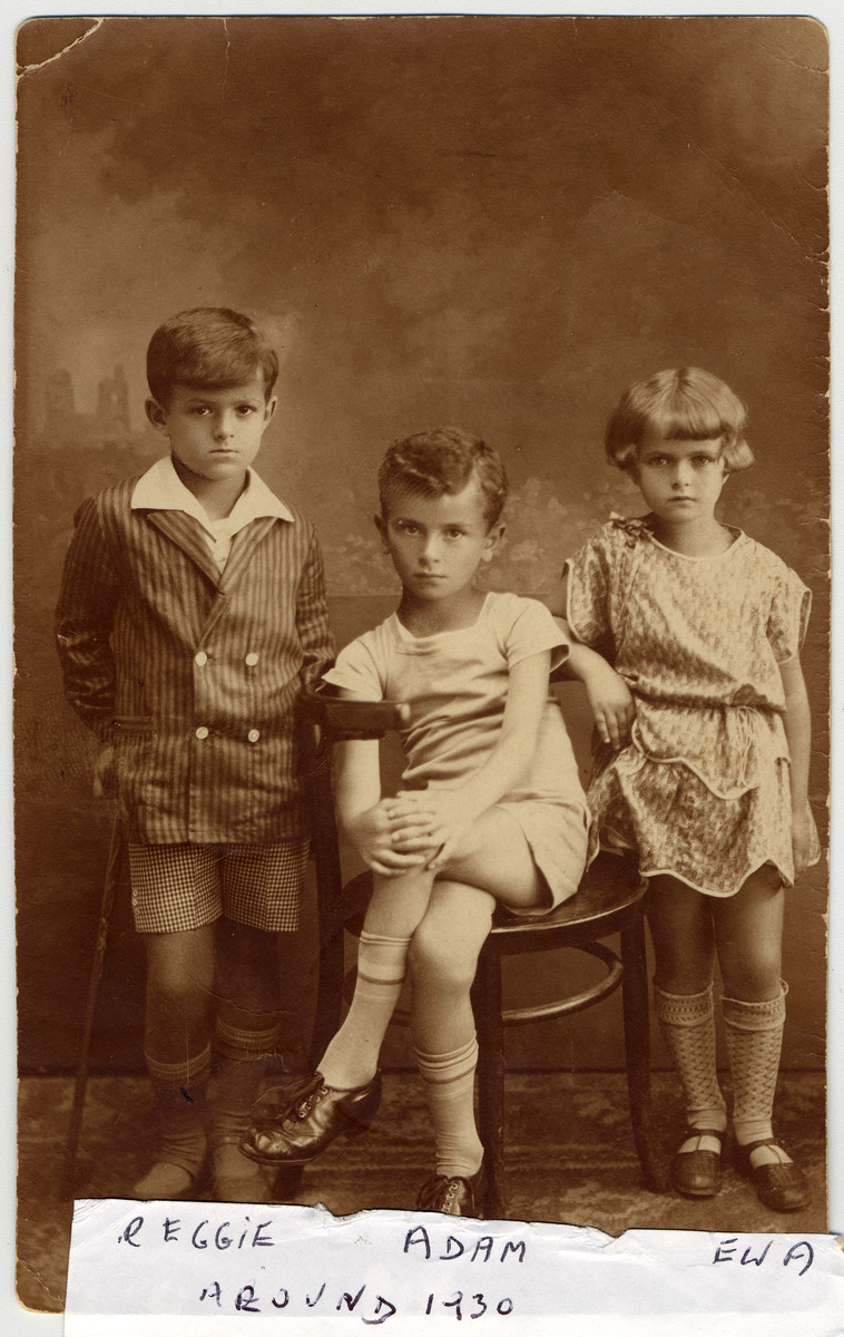 Studio portrait of three Polish Jewish children: Ignacy (Reggie) Wistreich, Adam Kahane, and Eva Wistreich.