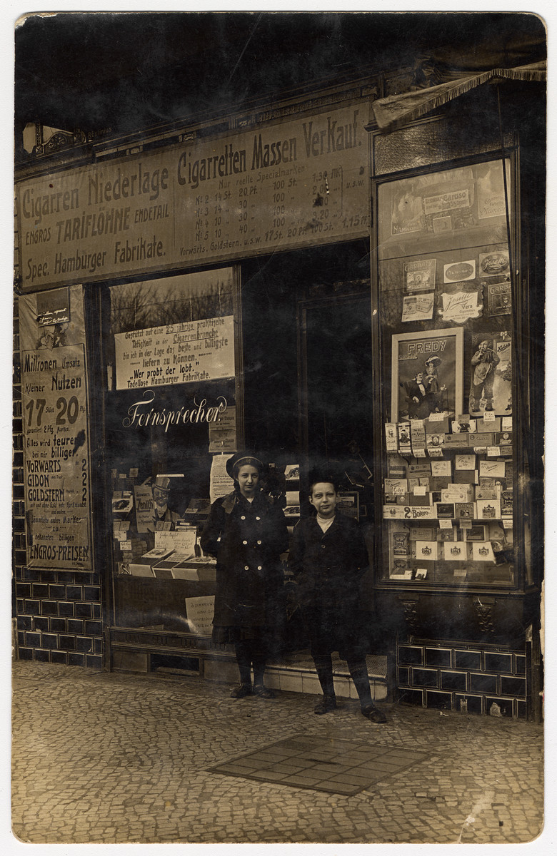 A brother and sister pose in front of their father's cigar store.

Pictured are Augusta and Karl Brager.