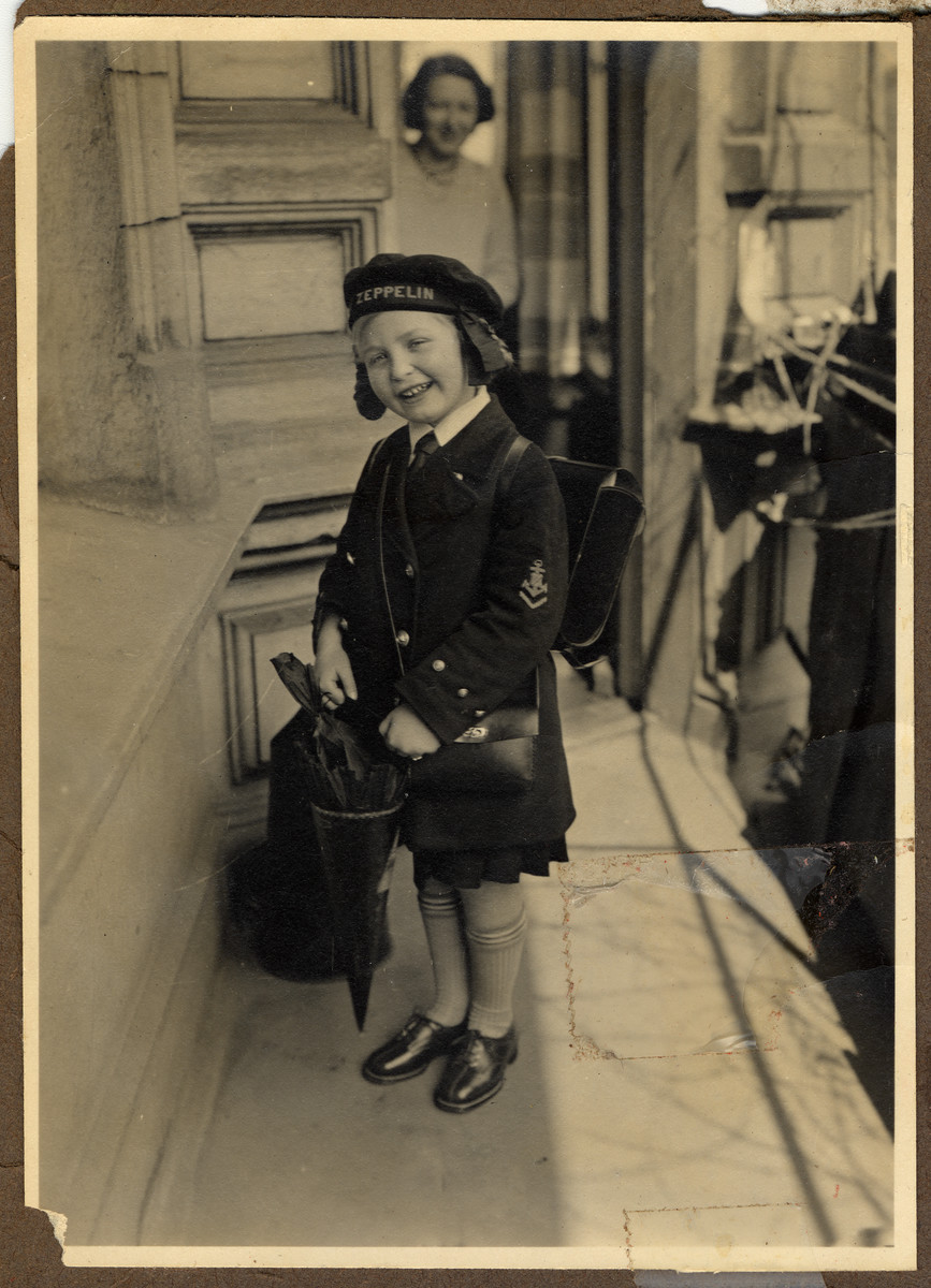 Helga Bujakowski leaves home carrying a back pack and cone filled with treats on her first day of school.

Her mother, Augusta, is pictured in the background.