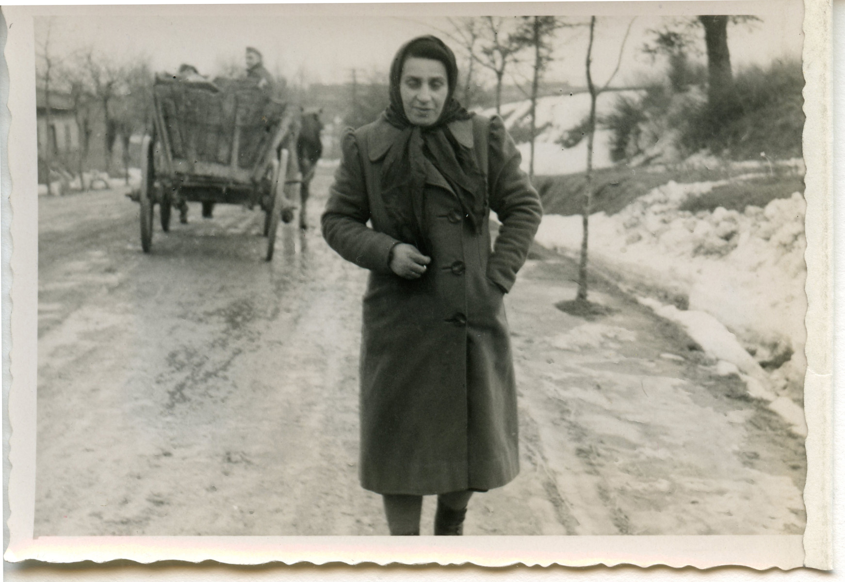 A woman walks down a snowy road [perhaps in Osieciny].