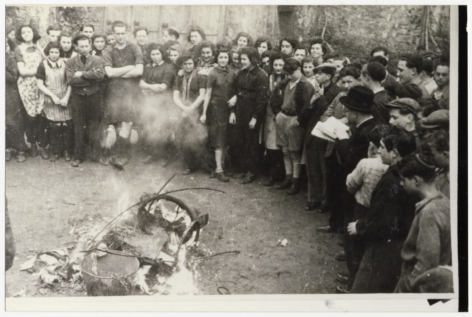 Jewish youth burn chametz [leavened bread] in preparation for the Passover holiday.

Among those pictured is Tosca Sussman in the back row.  Also pictured are Mary Auskerin, Arisch Schneider, Rabbi Sperber, Esther Weisner, Suzy Schindel, Erica Levin, Sonia Better, Tutti, Edith Metzger, Margot, David Graneck (work organizer), Annie Levin (nee Feldman), Lotte Aronowicz, and Ruth Ring (back center).
