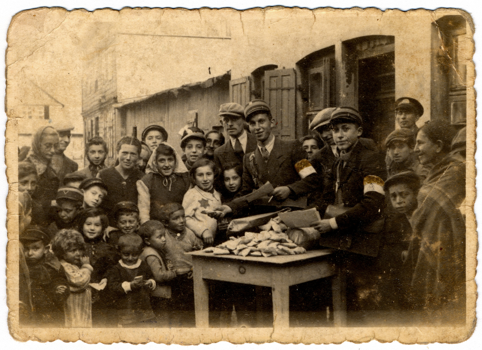 J. Lewkowicz and A. Jakobowicz distribute candy for the holidays to the children in the Lodz ghetto.  [See #89759 for black/white version]

The original caption reads "Memento for distribution of candy to children."