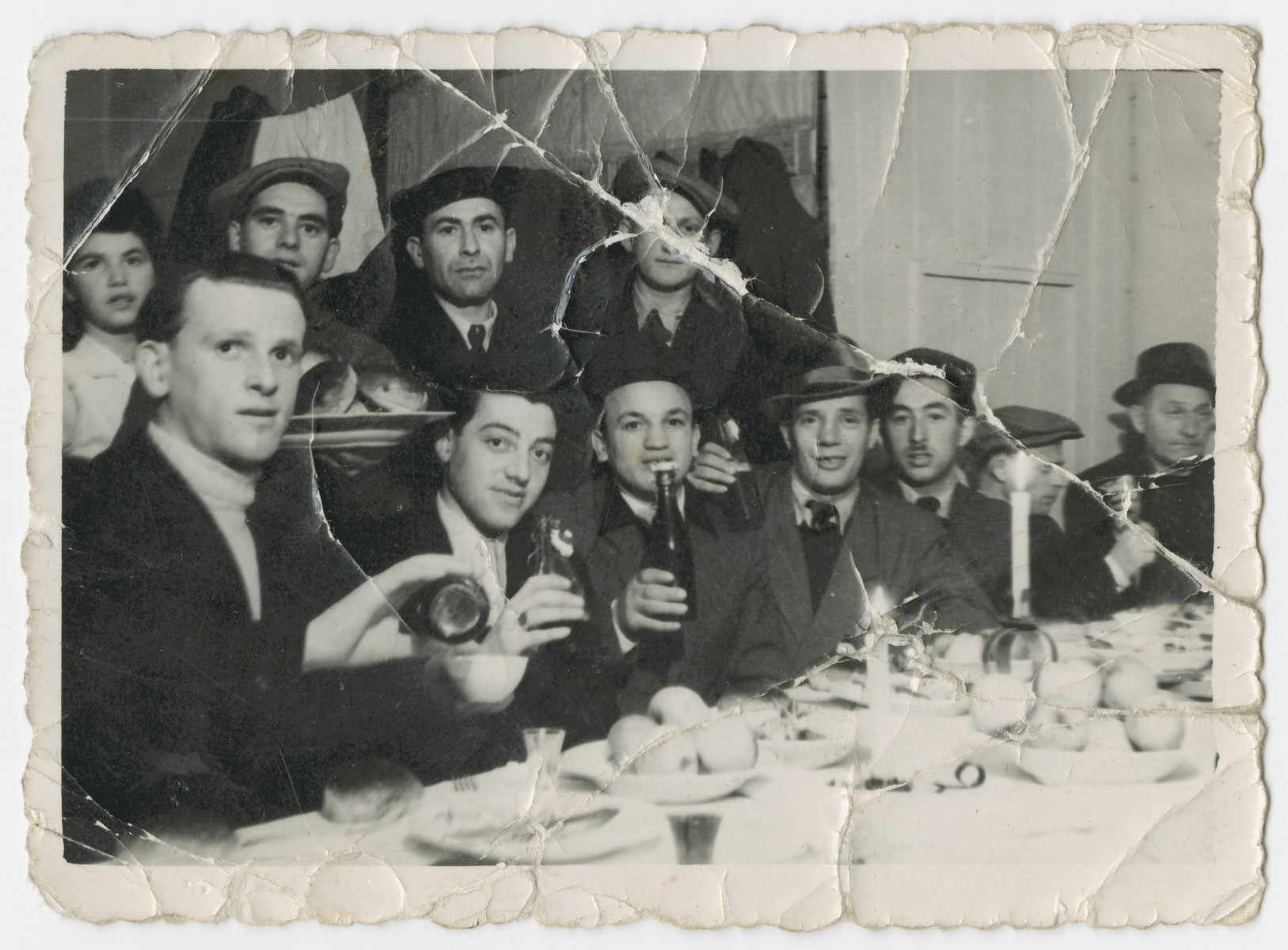 A group of men and women gather for a festive meal in the Bergen-Belsen displaced persons camp.

Among those pictured are David and Anna Rosenzweig, and their cousins Ben and Joe Rosenzweig.