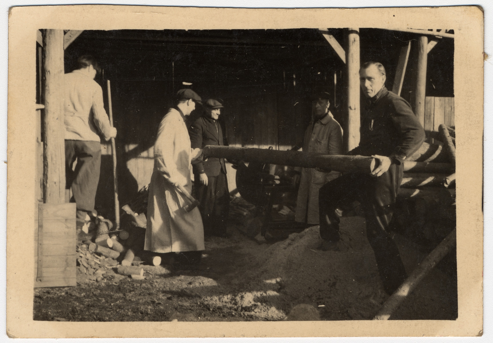 A group of men work in a lumber workshop, perhaps affiliated with a sanatorium.

The original Czech caption reads, "As a memento from Sanatorium, Buda and Zasmok."