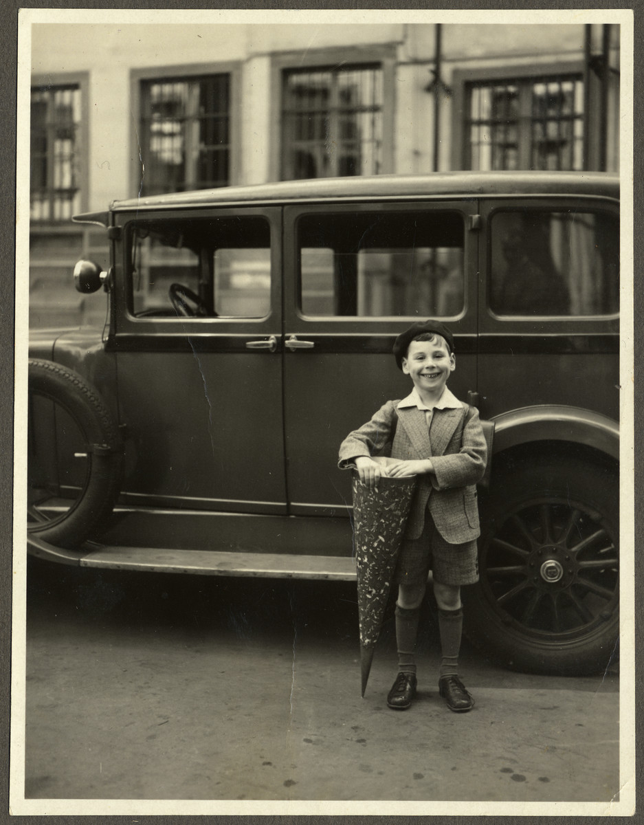 Paul Ehrenfeld poses by an automobile with a cone of sweets on his first day of school.