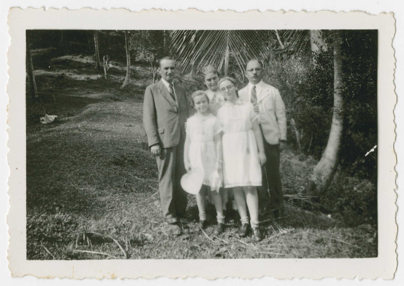 The Tauscher family poses outside in Trinidad where they arrived as refugees.

From left to right are [possibly Erich], Alice Tauscher, Bertha Tauscher, Trudie Tauscher and Victor Stecher.