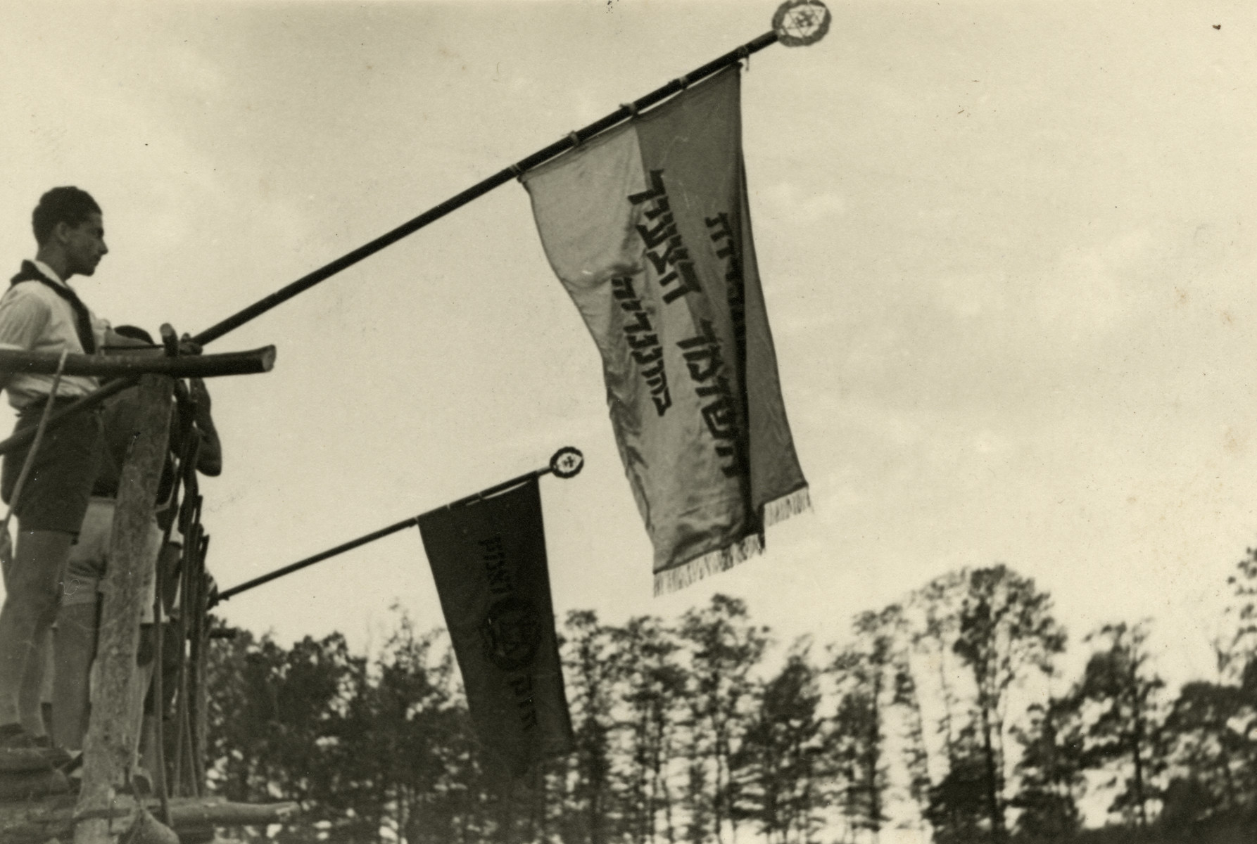 Ephraim Teichman holds the Shomer Hatzair flag in Shomria, a Zionist summer camp in postwar Hungary.
