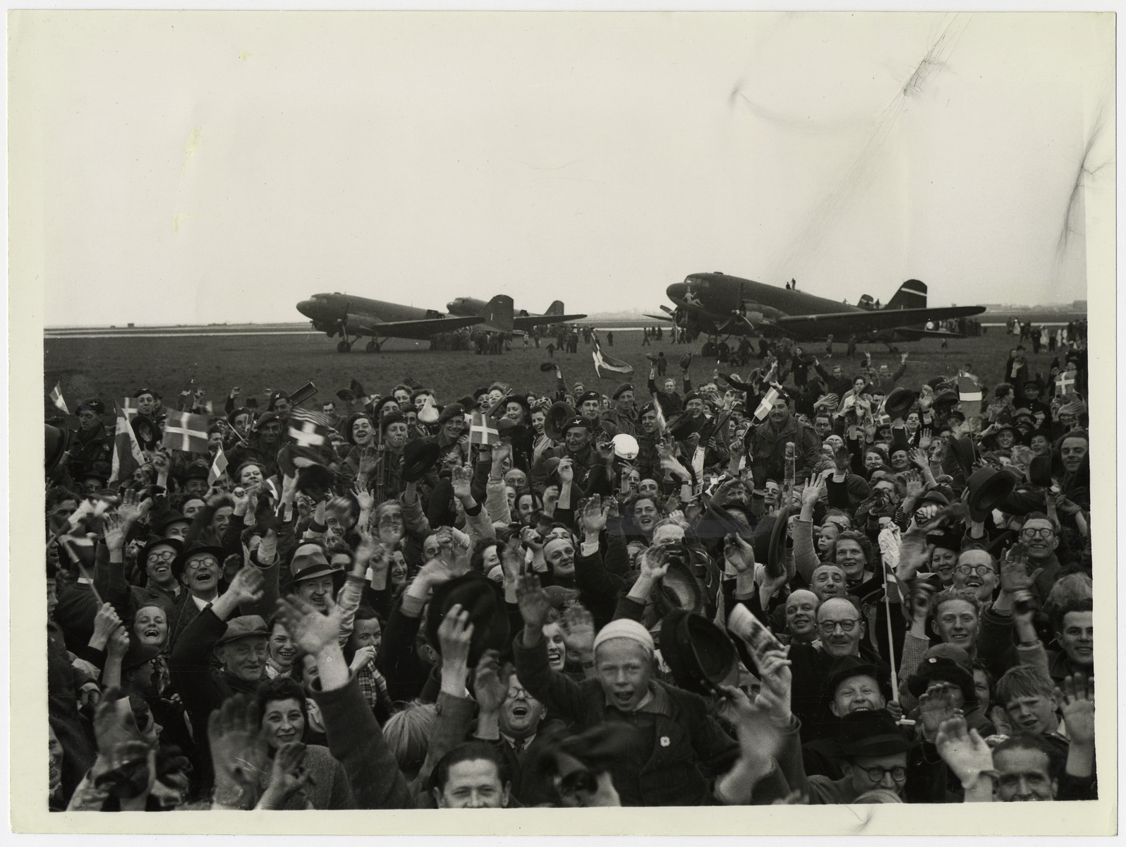 Official British photograph showing Danish civilians greeting the first British troops to land in Copenhagen.

The original caption reads: " The first British troops to land in Denmark were some of our Airborne troops, fresh from their race across Germany to link up with the Russians.
On the airfield, crowds broke through the barriers, and carried airborne troops shoulder high from their planes."
(NO. 8U 5339/A), WAR OFFICE PHOTO, CROWN COPYRIGHT RESERVED