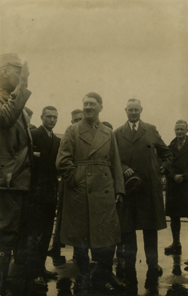 Adolf Hitler poses with comrades in Bremen, Germany. 

Original caption on album page reads, "Adolf Hitler being saluted by comrade. Aug. 1932, Bremen, Germany."