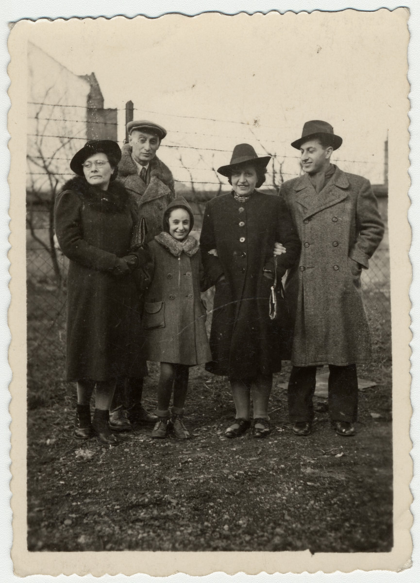 Members of the Engel family stand by a fence on their after the war.

Pictured are Greta Stoessler Engel, Ludwig Engel, Katie Engel, Marta Mandler (a cousin of Greta) and Victor Adler (b. 1929; a cousin of Katie).