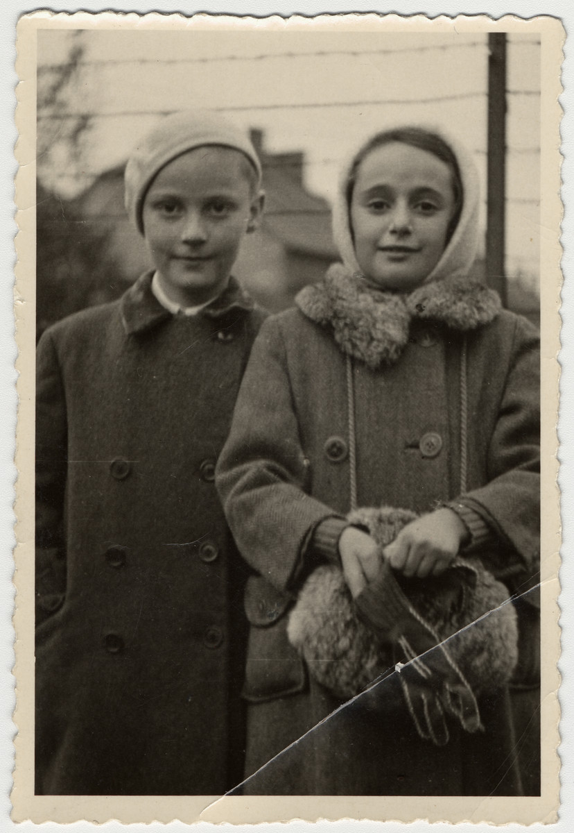 Katerina and Adolph Engel stand in front of a barbed wire fence in a small town in Moravia during the winter of 1946.