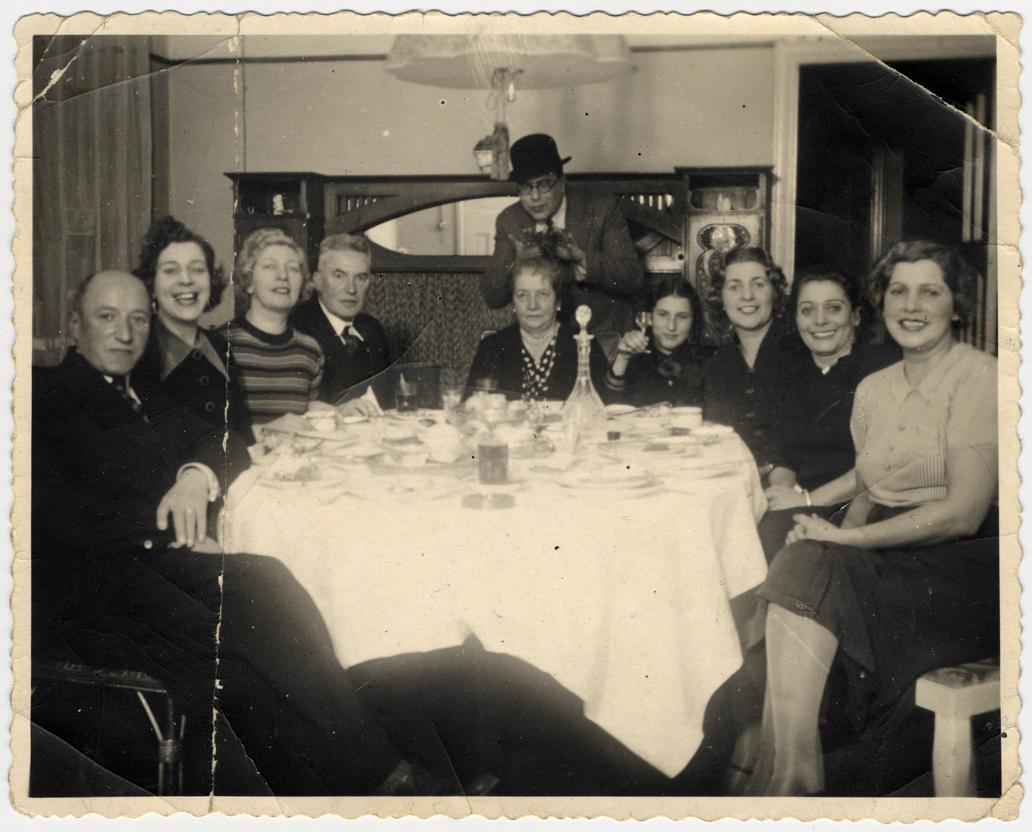 A Latvian-Jewish family gathers around its dining room table.  The photo was taken in the home of the donor's aunt, Gusti Jakobson Akermann.

Left to right: Oskar (Gusti's husband), Lena and Rita Jakobson (sisters of Klara and Gusti), Marta Schiftan (the mother-in-law of Tania Jakobson Schiftan), Luba Akermann, Klara Schwab, Hermina Jakobson, and Gusti Akermann.