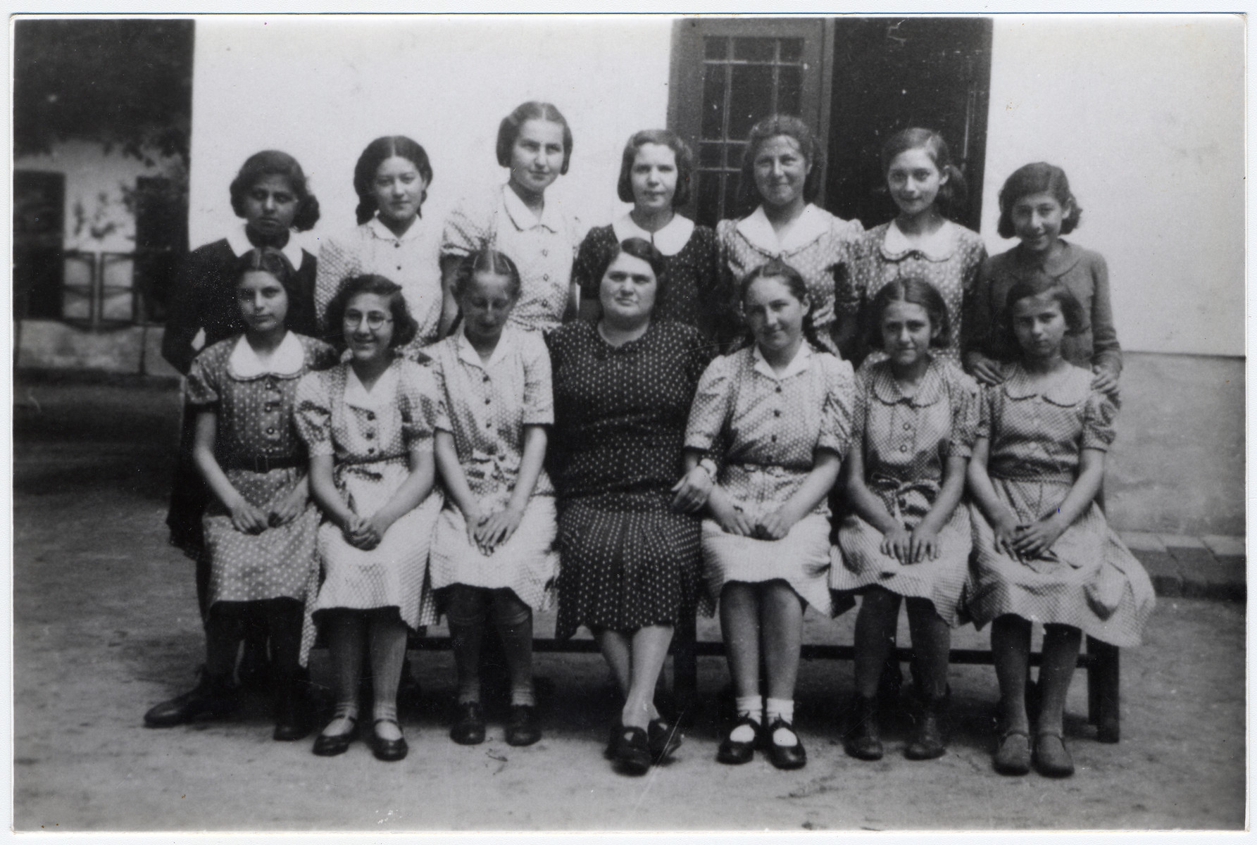Class photo of the graduating class from the Jewish school of Vac.  

Marta Ganzl is seated to the left of the teacher.  Her sister Erna is to the teacher's right.