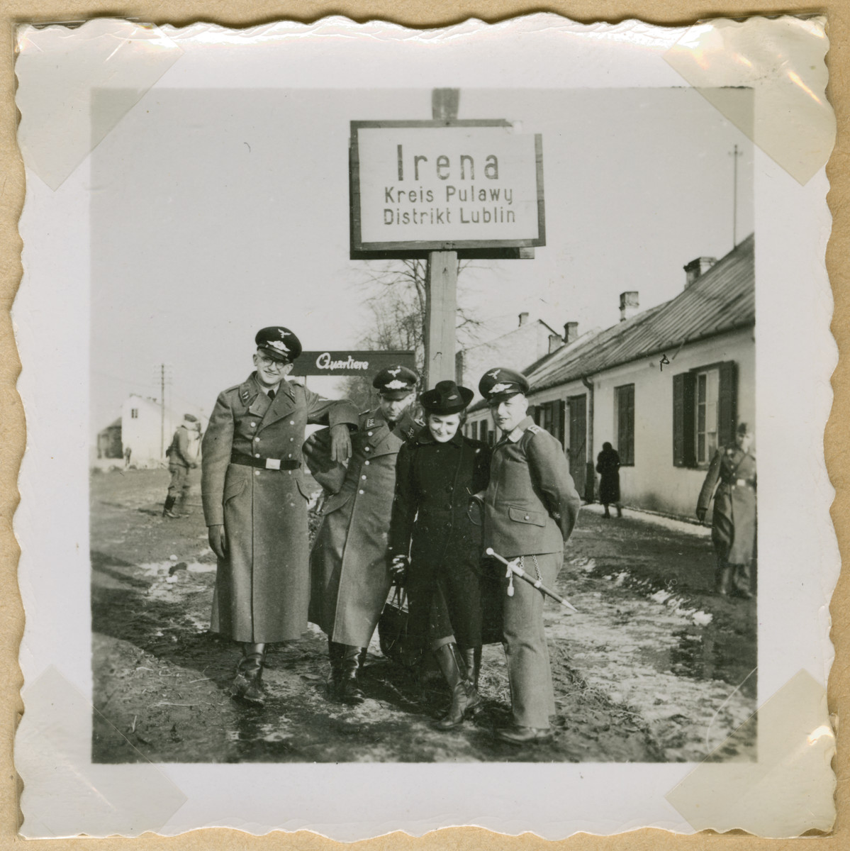 Three German soldiers and a woman pose underneath a sign to Irena/Pulawy.