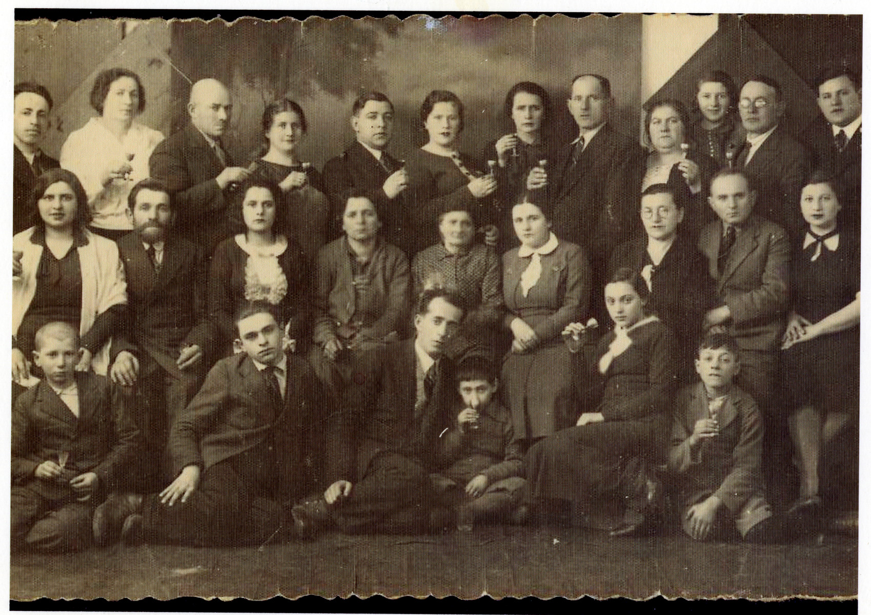 The extended maternal family of Sara Borzykowski celebrate the impending emigration of a cousin.  

Pictured are members of the Krause family and Wilhelm families (Sara Fogelman's maternal relatives).  Among those pictured are Hersh Fogelman (5th from left, top row) and his wife Sara Fogelman standing next to him.  Wolf Borzykowski (Sara's brother) is standing on the top row, far right.