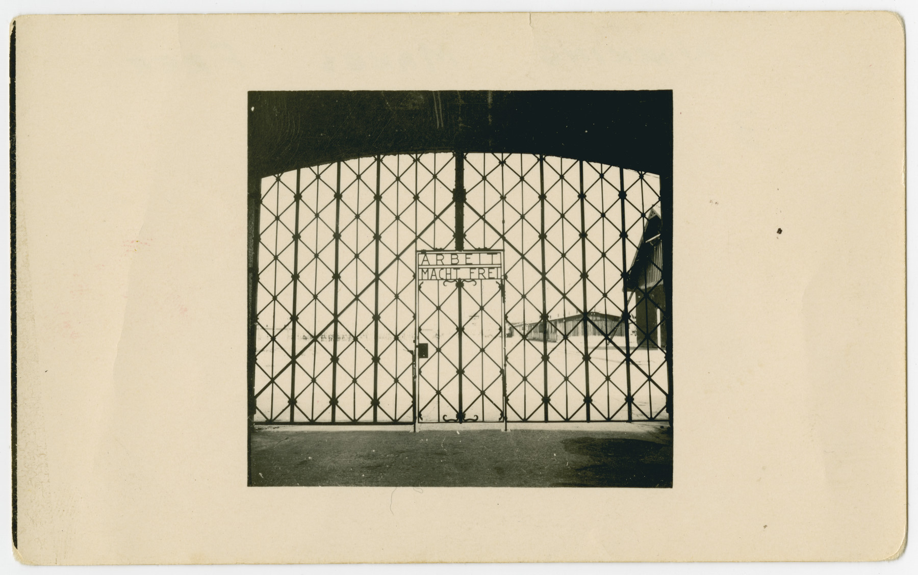View of the gated entrance to the Dachau concentration camp with the sign, "Arbeit Macht Frei" [Work makes you free].