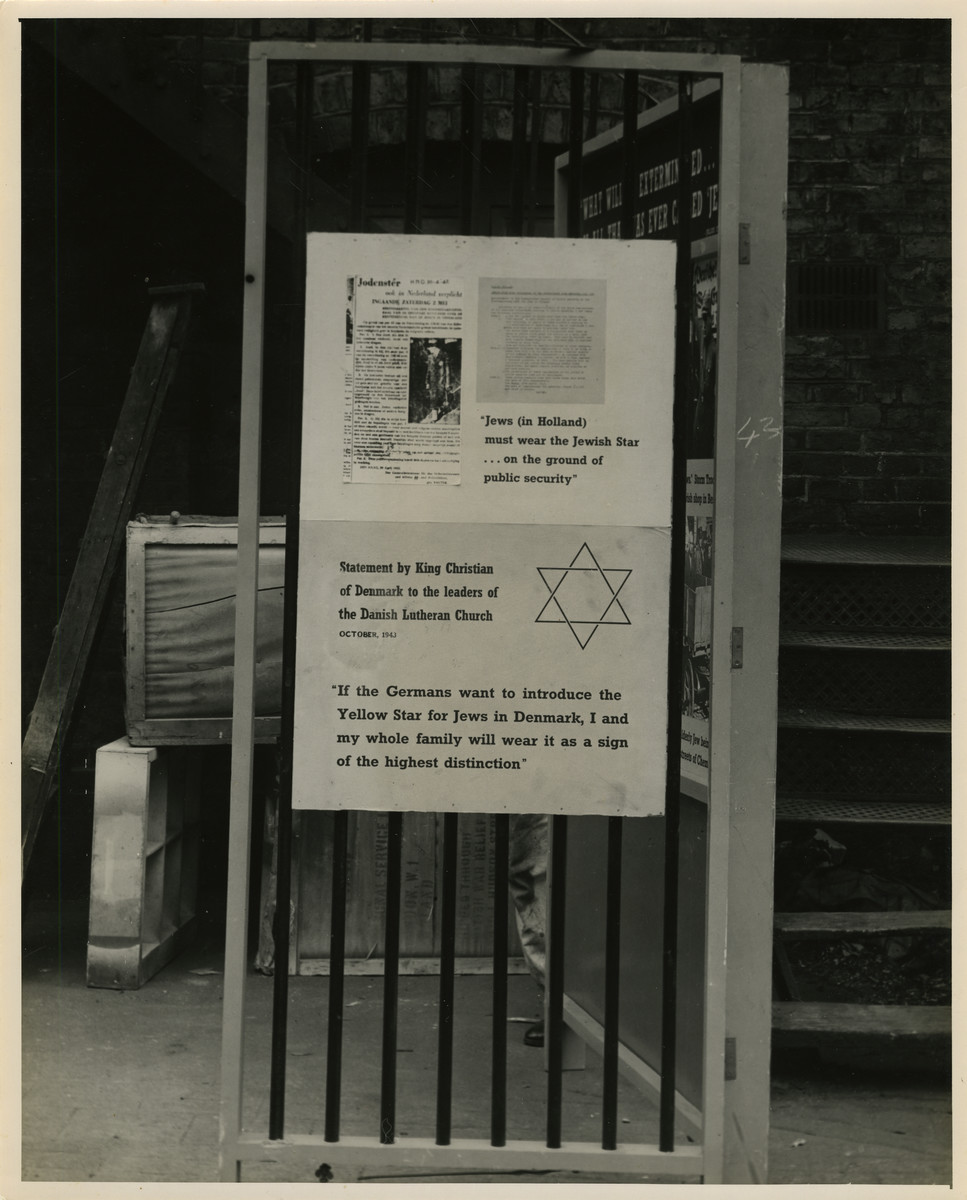 Panel from a 1944 exhibition in London, England, entitled "Germany- the Evidence" showing resistance to the Nazi Regime in Holland and Denmark. 

A panel that reads "Jews (in Holland) must wear the Jewish Star... on the ground of public security." "Statement by King Christian of Denmark to the leaders of the Danish Lutheran Church. October 1943. If the Germans want to introduce the Yellow Star for Jews in Denmark, I and my whole family will wear it as a sign of the highest distinction." 

The back of the photo reads "British Official Photograph; Distrbuted by the Ministry of Information. D. ; The Evil We Fight.; Ministry of Information Exhibition priduced by Display &Exhibitions Division for show all over Great Britain.; Display panel"