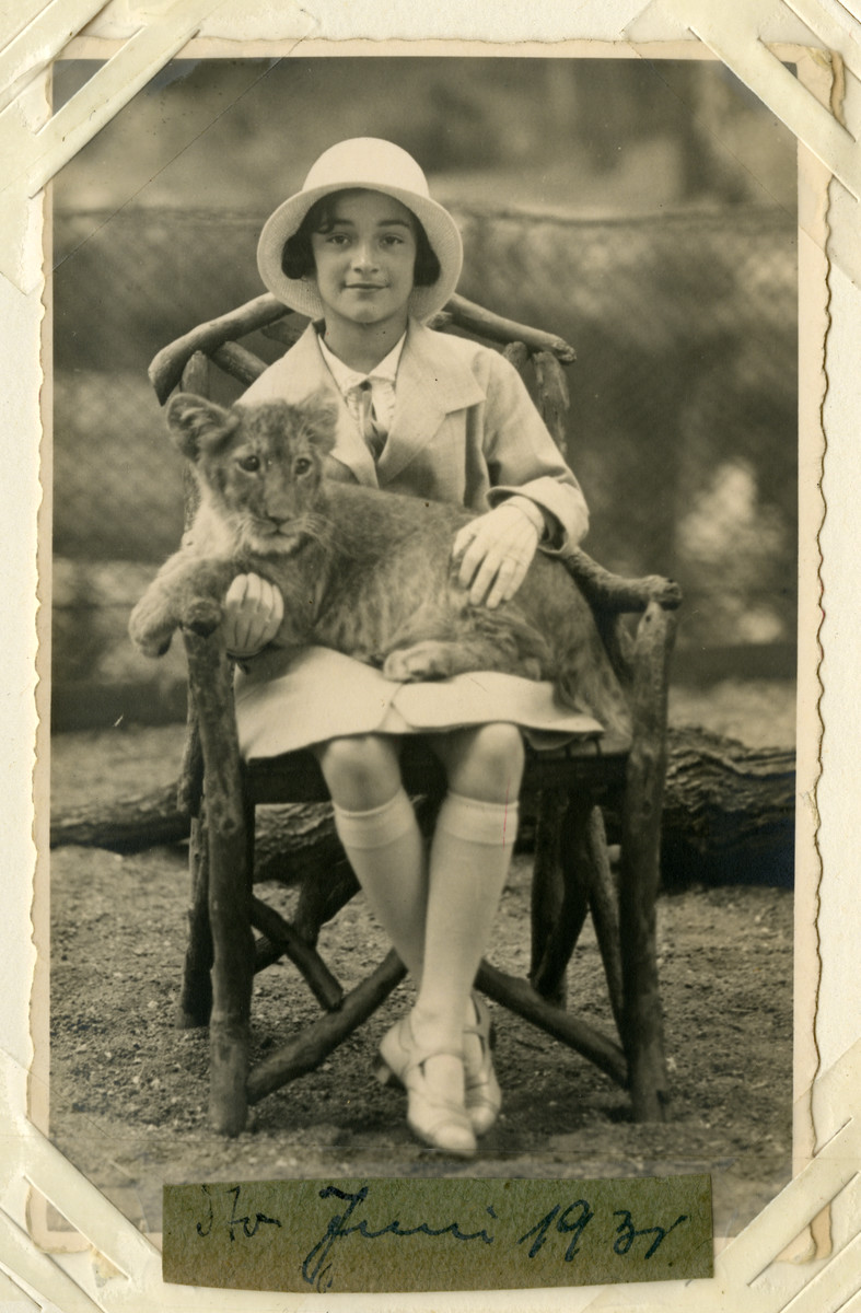 Helga Reinsch sits with a baby lion in her lap.