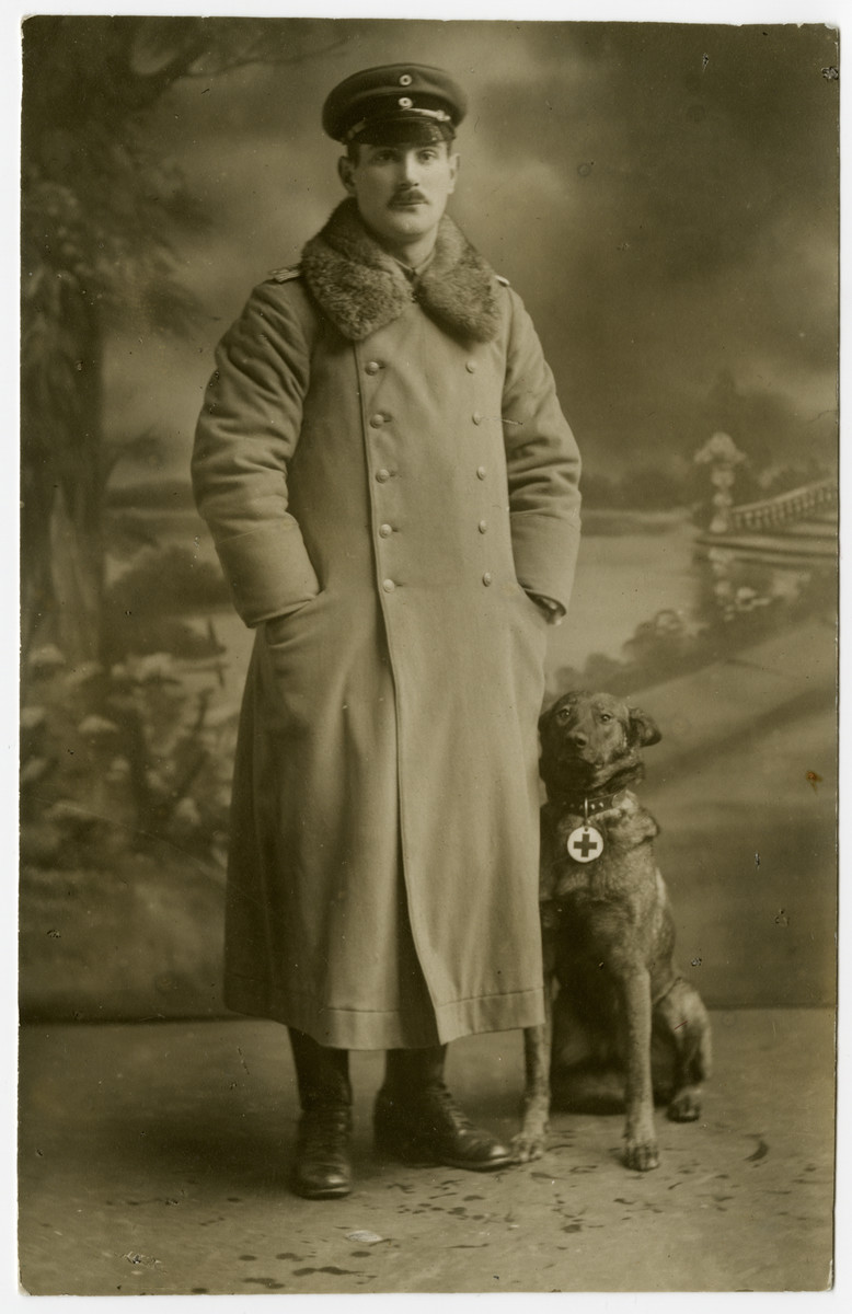 A portrait of Karl Reinsch in military uniform with a service dog bearing a Red Cross tag.