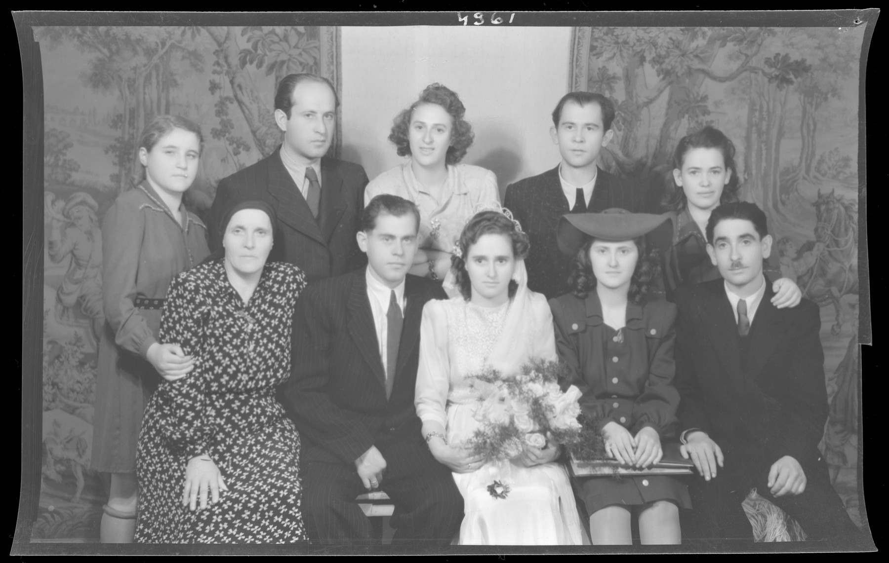 Studio group portrait of the wedding of Albert and Sara Grunwald.

Behind them are Kalman and Irina Grunwald.