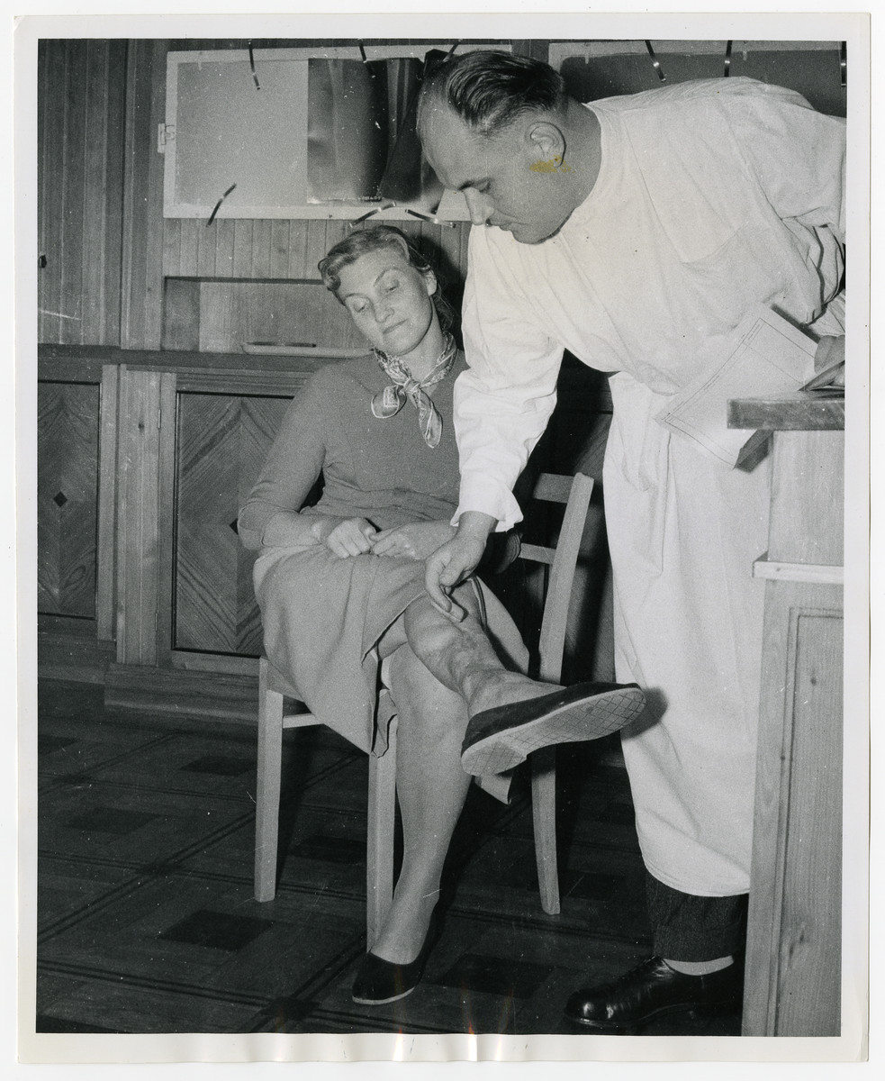 A physician examines  Maria Kusmierczuk, a survivor of medical experiments performed when she was a prisoner in the Ravensbrueck concentration camp.