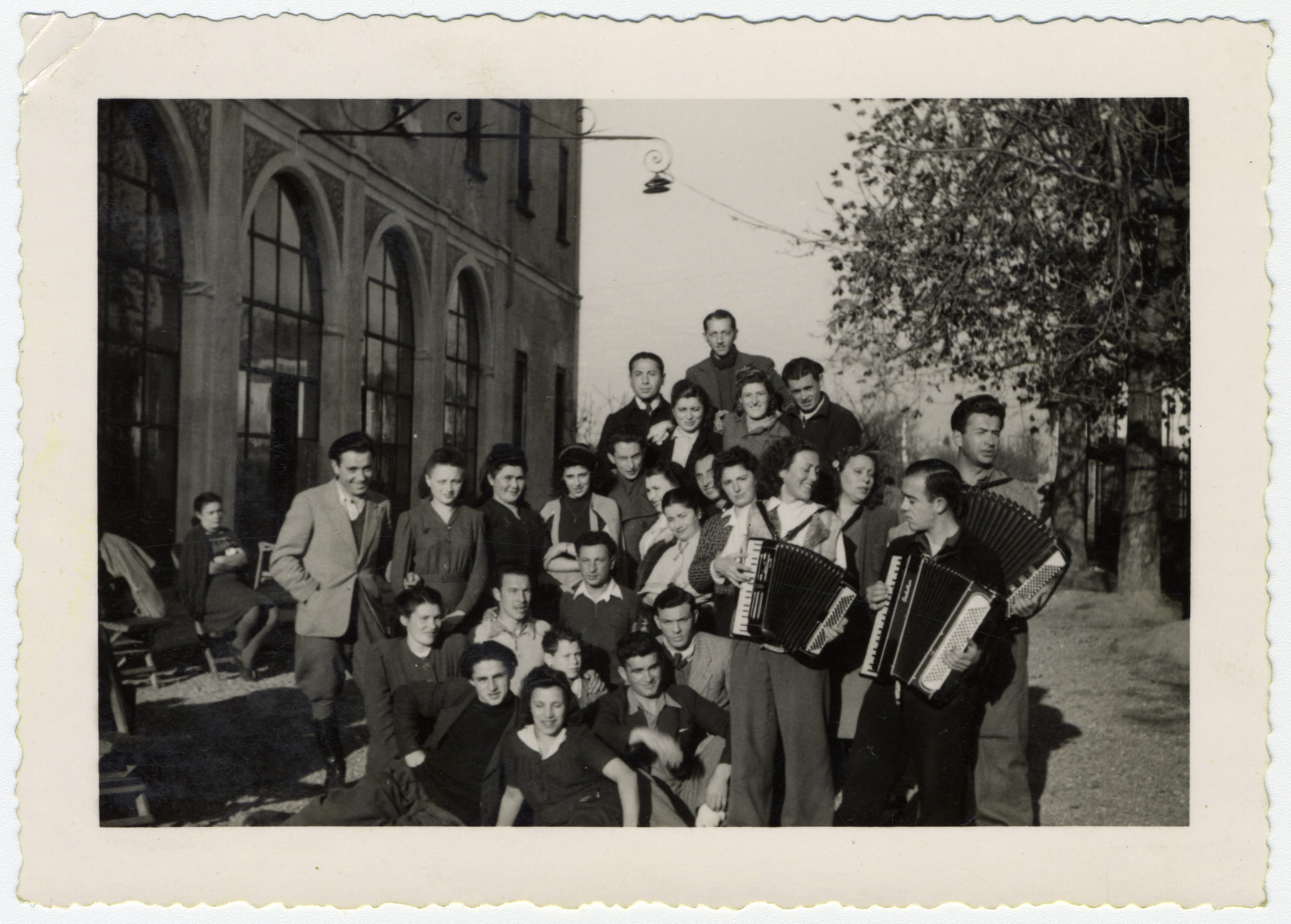 Group portrait of Jewish displaced persons in Graz, Austria.

Pictured playing accordion in the front, second from the right is Gerta Bagriansky.