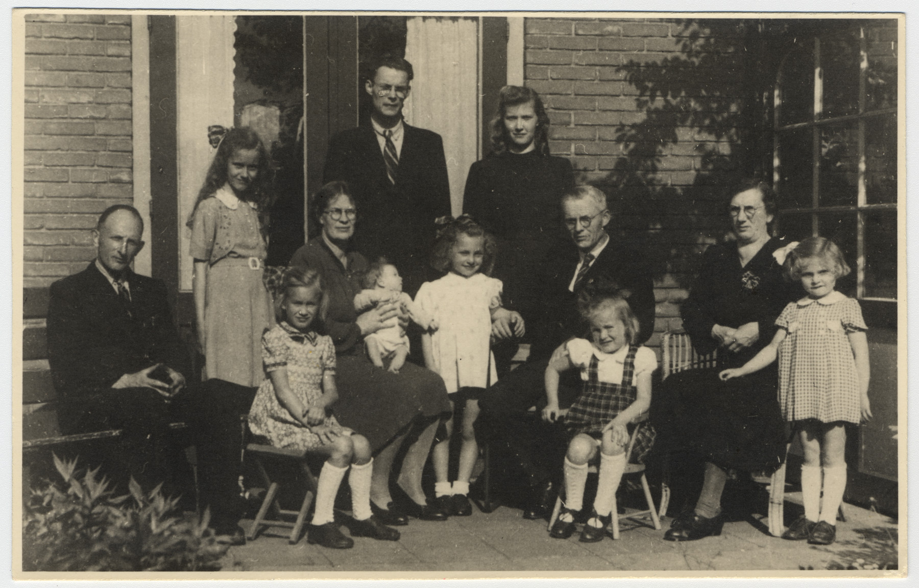Group photograph of two Dutch rescuers families and the two Jewish sisters they saved.

Pictured on the left are Dirk and Cornelia van der Kamp and their three daughters.  Marjetta Kleerhoper is next to them in a white dress.  Anton and Wilhelmina Heger are seated on the right with Elisabeth Kleerhoper.  The Heger children are in the back.