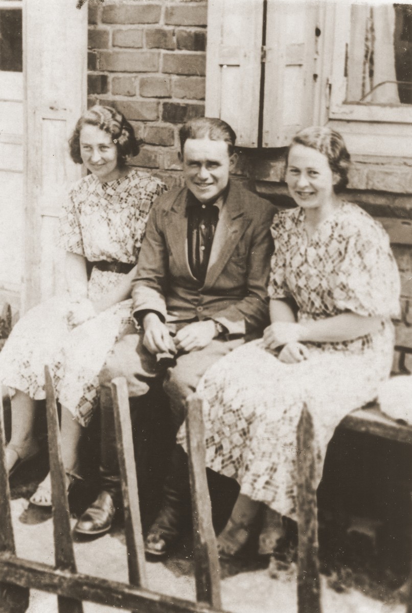 Three young Jewish men and women pose outside a private home in Goloby.

Pictured are Zelda and Eta Leikach and Motel Kuris outside the Leikach home.