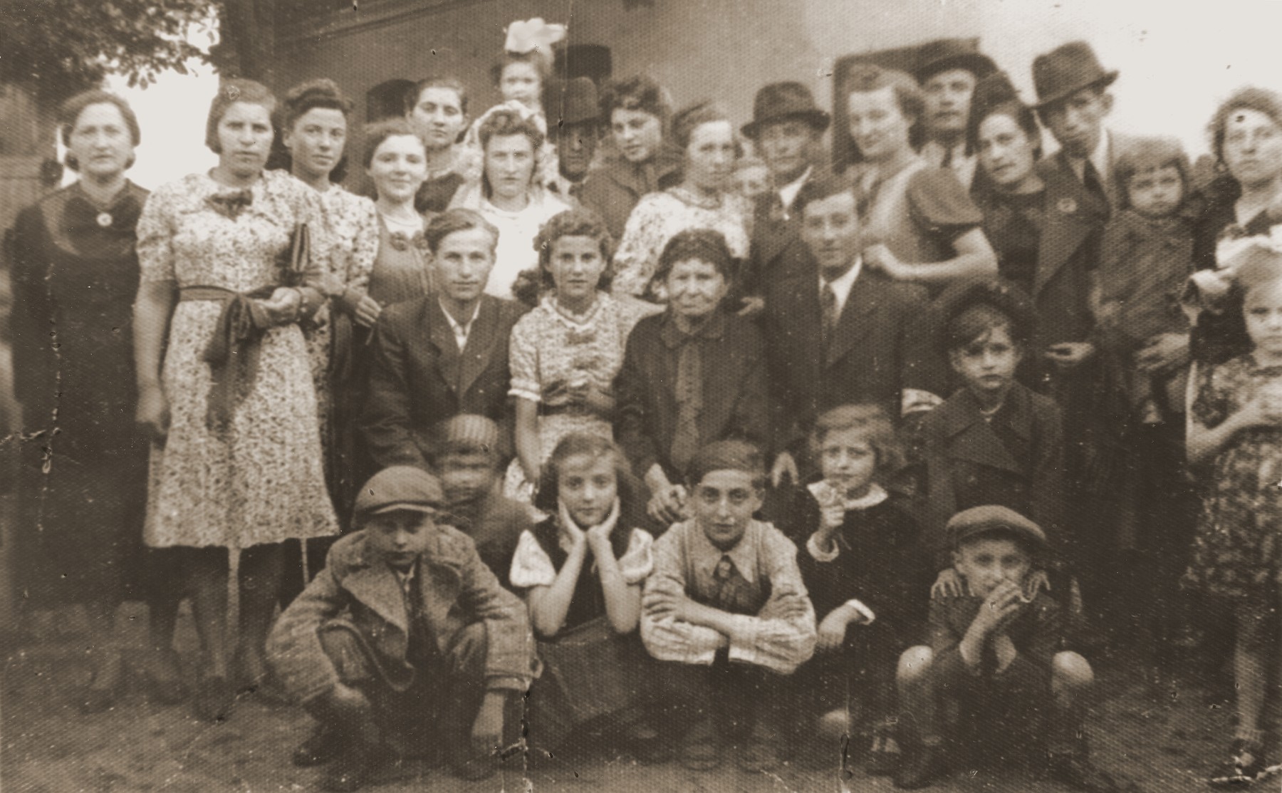 Family portrait  taken on the occasion of the wedding of Netl Moncznik, the cousin of Berl Moncznik.  

This was the last Jewish wedding in Niwka before the outbreak of the second World War.  Pictured in the front row from left to right are: Heniek Polturok (cousin); Jadzia Moncznik; Szlamek Moncznik and two unidentified children.  Sitting in the middle row are: Leon Moncznik (cousin); Dorka Moncznik; Jehudit Moncznik (grandmother) and Berl Moncznik.  Among those standing in the back row are Lea Moncznik (left) and the bride, Netl Moncznik.