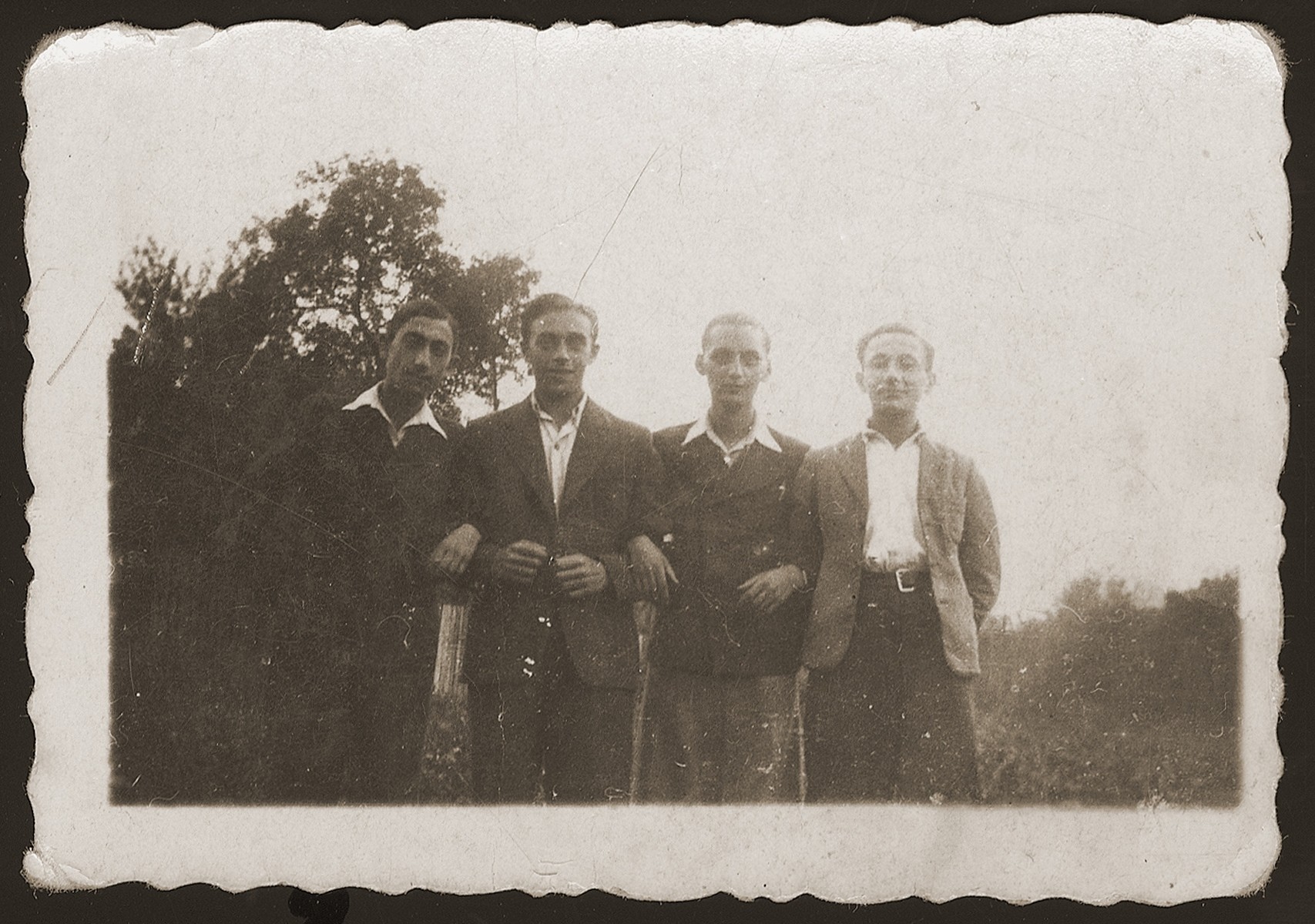 Group portrait of four childhood friends from Dabrowa Gornicza reunited in the New Palestine displaced camp near Salzburg. 

Standing from left to are: Moniek Rozen, Szlamek Rozencwajg, Jakub Bajtner and Moniek Szeps.