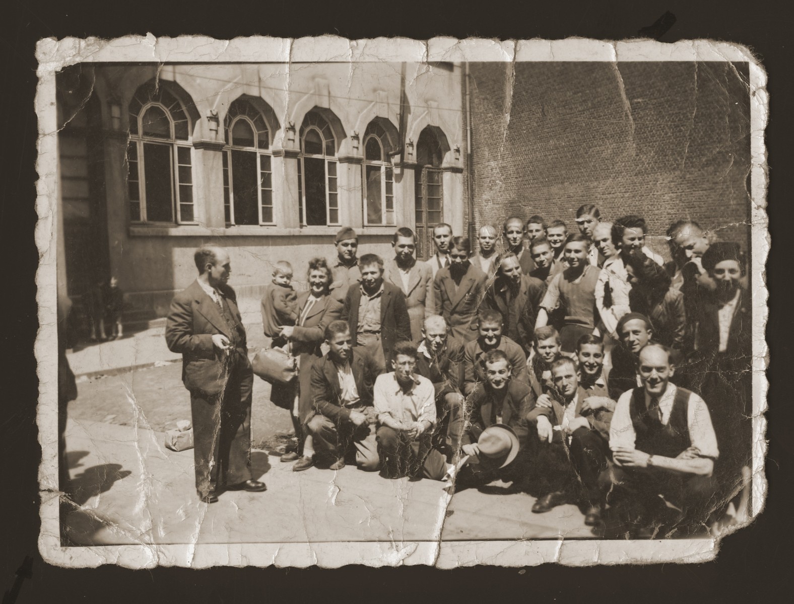 Marjana Ulman (standing, far right) and David Majer Zalc (kneeling, far right) among a group of young people posing on a street corner in Antwerp.